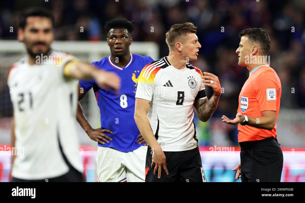 Lyon, France. 23rd Mar, 2024. Soccer: International match, France - Germany, Groupama Stadium. Germany's Toni Kroos (2nd from right) discusses with referee Jesus Gil Manzano (right) from Spain. Credit: Christian Charisius/dpa/Alamy Live News Stock Photo