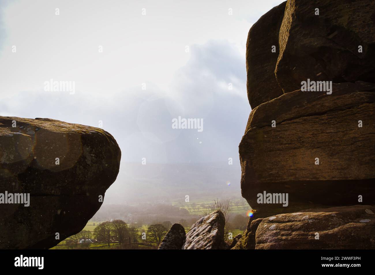 Scenic view of a landscape through rock formations under a cloudy sky at Brimham Rocks, in North Yorkshire Stock Photo
