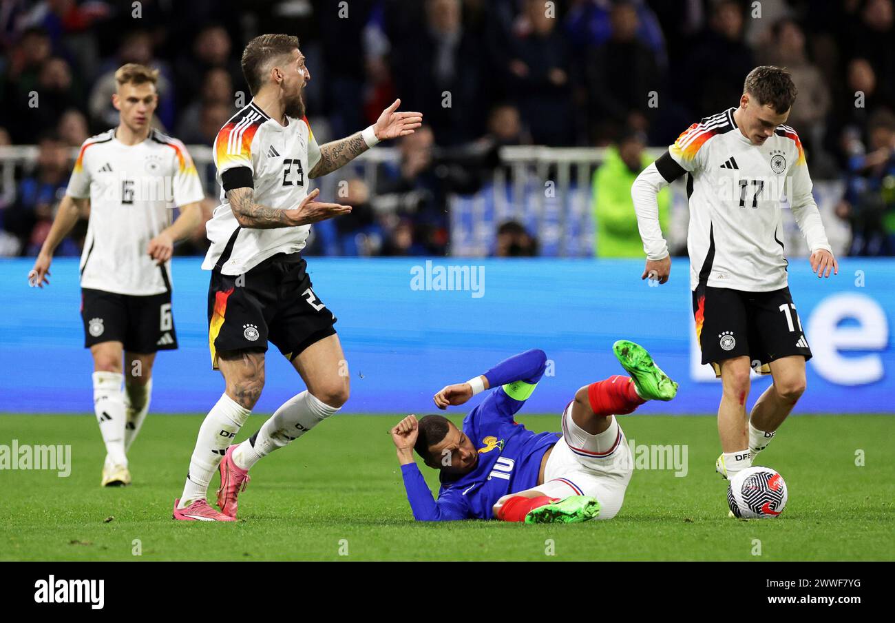 Lyon, France. 23rd Mar, 2024. Soccer: International match, France - Germany, Groupama Stadium. Germany's Robert Andrich (2nd from left) reacts next to France's Kylian Mbappé (2nd from right). Credit: Christian Charisius/dpa/Alamy Live News Stock Photo