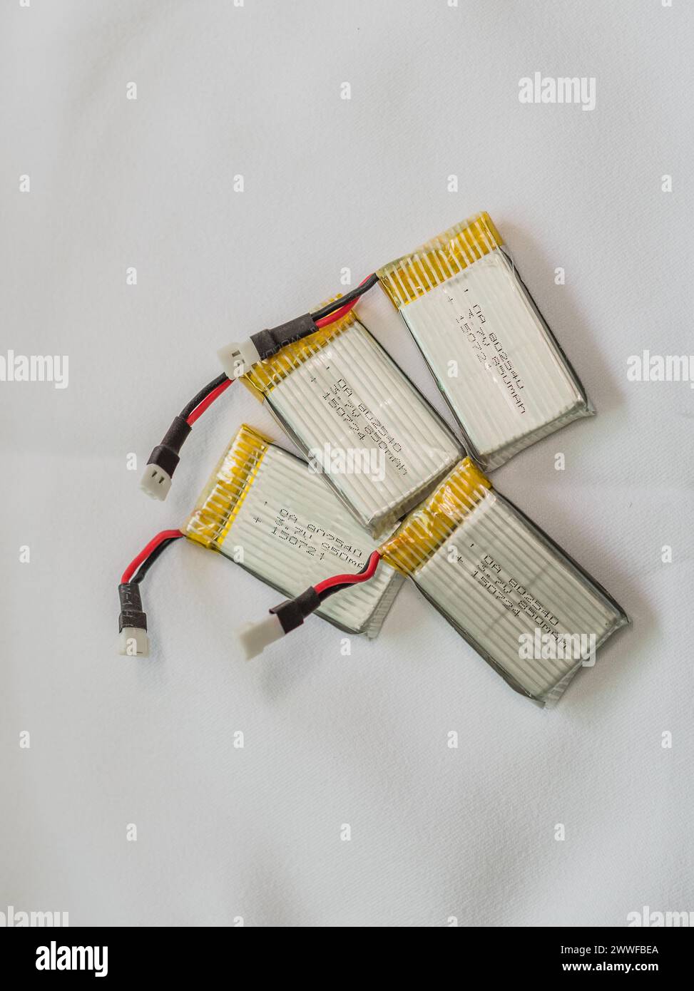 Several lithium polymer batteries with connectors and yellow tape on a white surface, in South Korea Stock Photo
