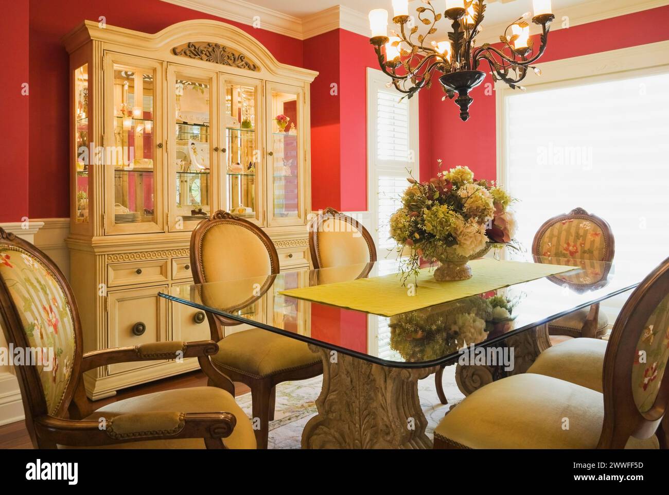 Glass top table with highback wooden and upholstered chairs in dining