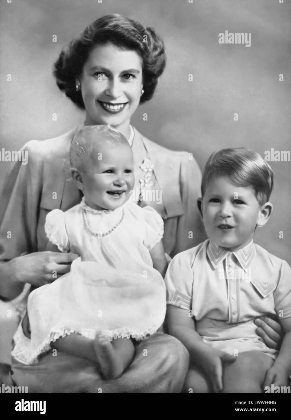 Elizabeth II is pictured with her first two children, Charles III and Princess Anne, in a portrait that captures a moment of royal family life before her ascension to the throne. Taken circa 1951, this image shows Elizabeth as a princess, mother to Charles, who would later become king, and Anne, providing a glimpse into their early years and the personal side of a family destined to lead the British monarchy. Stock Photo