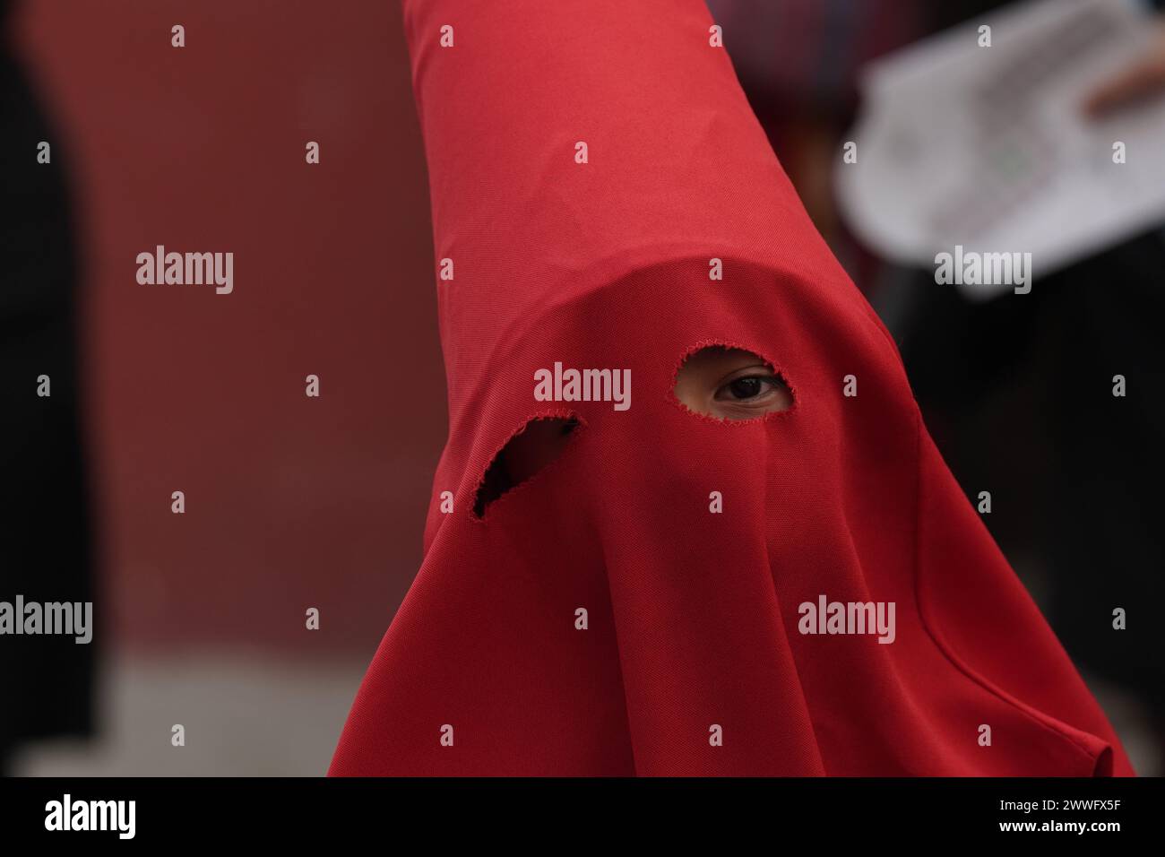 Antigua, Guatemala. 23 March, 2024. A young penitent, wearing hooded ...