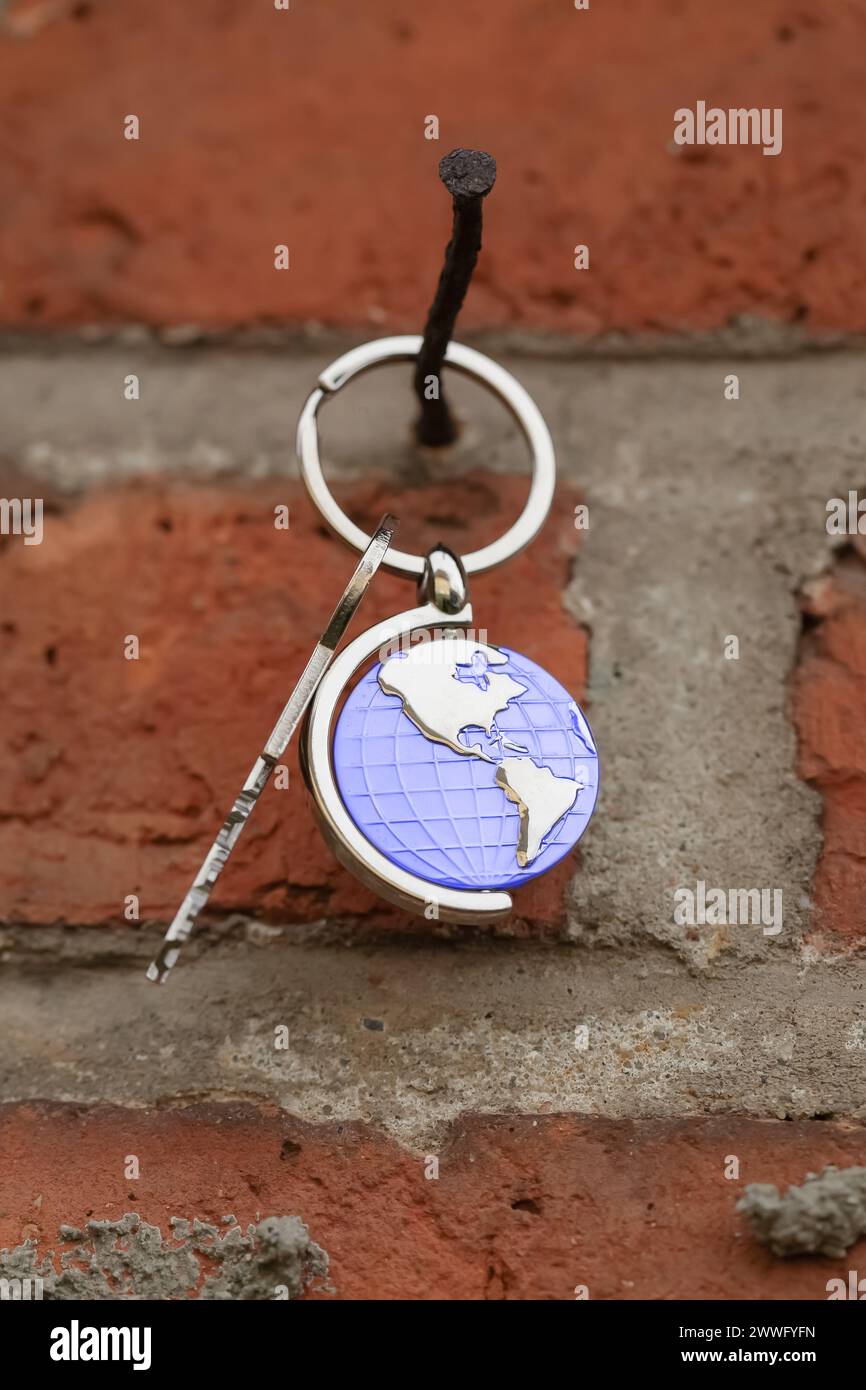 World symbol with silver keys on abstract background. Real estate concept Stock Photo