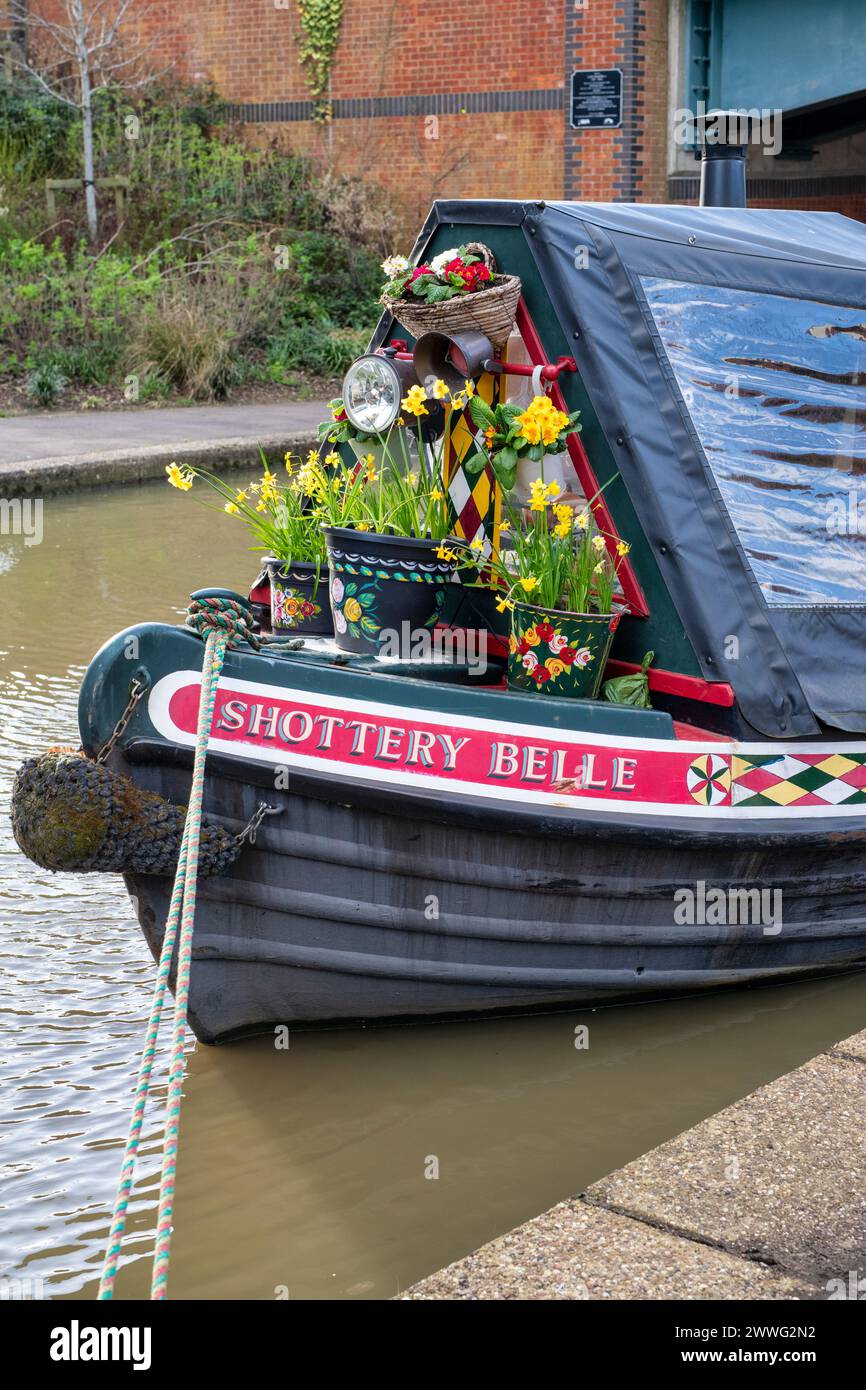 Spring flowers on the front of a canal boat on the Oxford canal in Banbury.  Castle Quay Waterfront. Banbury, Oxfordshire, England Stock Photo