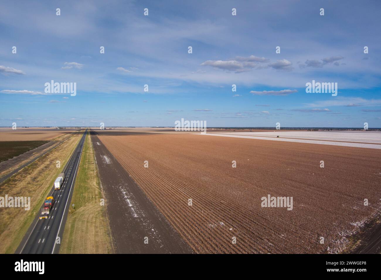 Aerial of Warrego Highway passing cotton fields being harvested near Dalby Queensland Australia Stock Photo