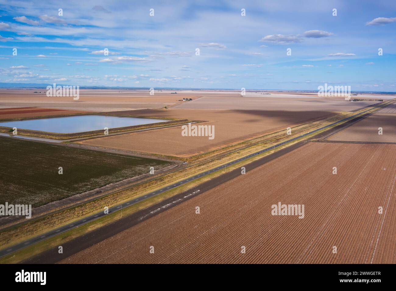 Aerial of Warrego Highway passing through harvested cotton fields with on farm water storage near Dalby Queensland Australia Stock Photo