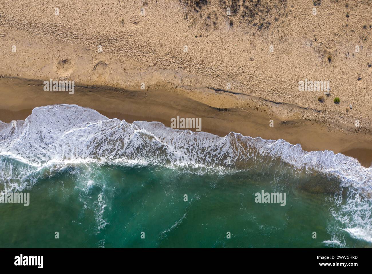 Aerial view of a remote sandy beach and sea waves by drone Stock Photo