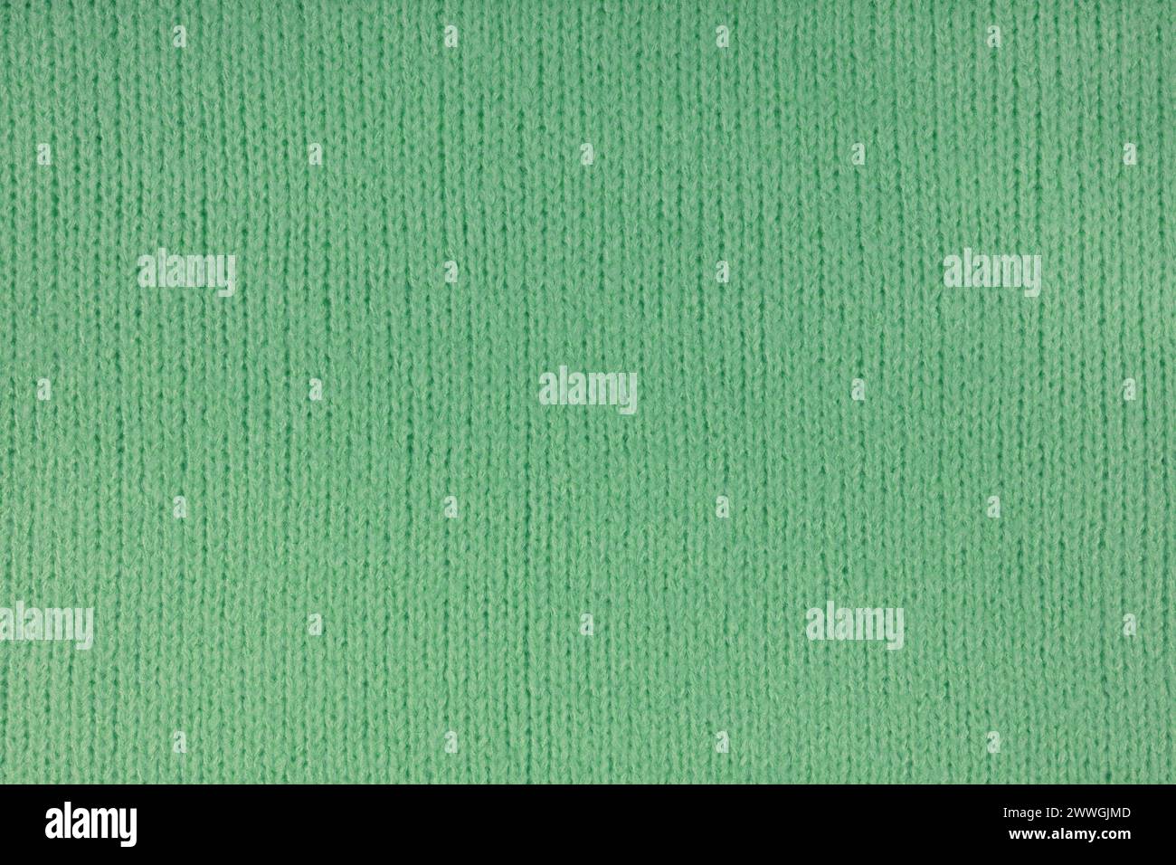 Green knitted woolen jersey fabric, sweater, pullover texture background. Fabric abstract backdrop, cloth wallpaper Stock Photo