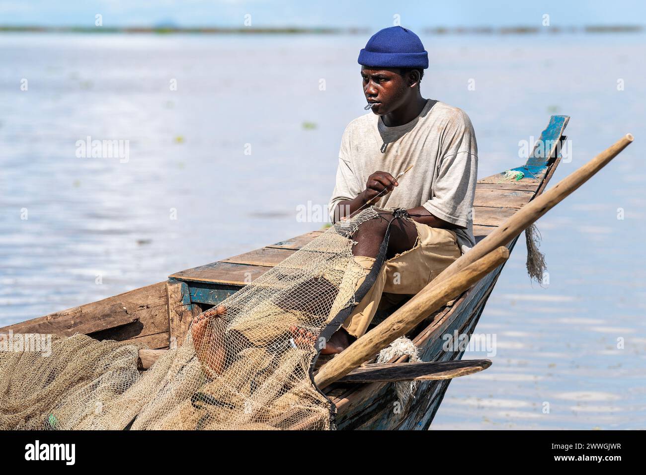 A fisherman repairs a net on the shores of Lake Chilwa in the Machinga district of Malawi. Trocaire and its local groups are helping locals patrol Lake Chilwa to ensure there is no illegal fishing. In 2015, the lake completely dried out because of climate change, which led to the loss of most species of fish, putting more pressure on another vital food source. Picture date: Tuesday March 5, 2024. Stock Photo