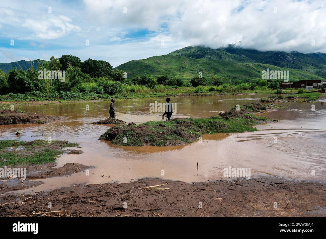 Young men fish in a river in the flooding-prone regions around Lake Chilwa in the Machinga district of Malawi. Picture date: Tuesday March 5, 2024. Stock Photo