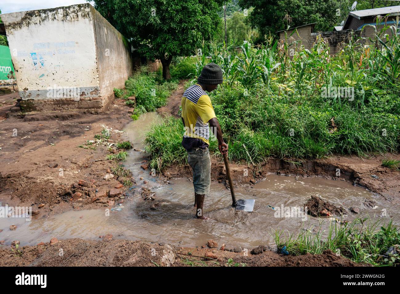 A man cleans his hoe in the flooding-prone regions around Lake Chilwa in the Machinga district of Malawi. Trocaire is training farmers in new diverse crops that can tolerate weather extremes a little more than maize can. Picture date: Tuesday March 5, 2024. Stock Photo