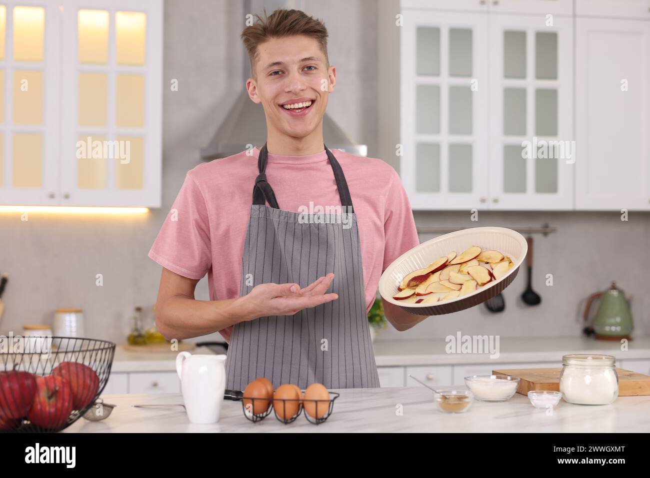 Smiling food blogger explaining something in kitchen Stock Photo