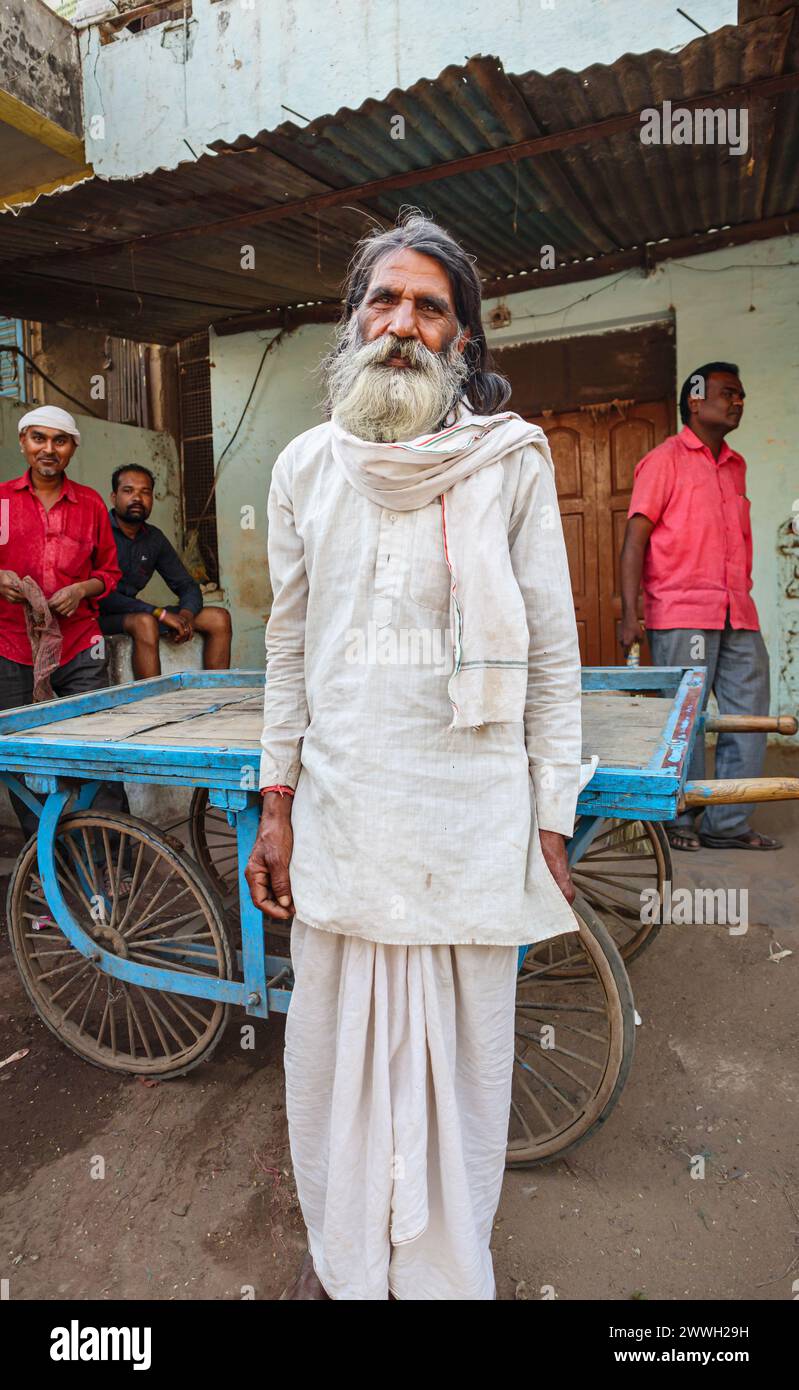 Heavily bearded elderly local Indian man in typical everyday dress standing on the roadside in a town in Umaria district of Madhya Pradesh, India Stock Photo