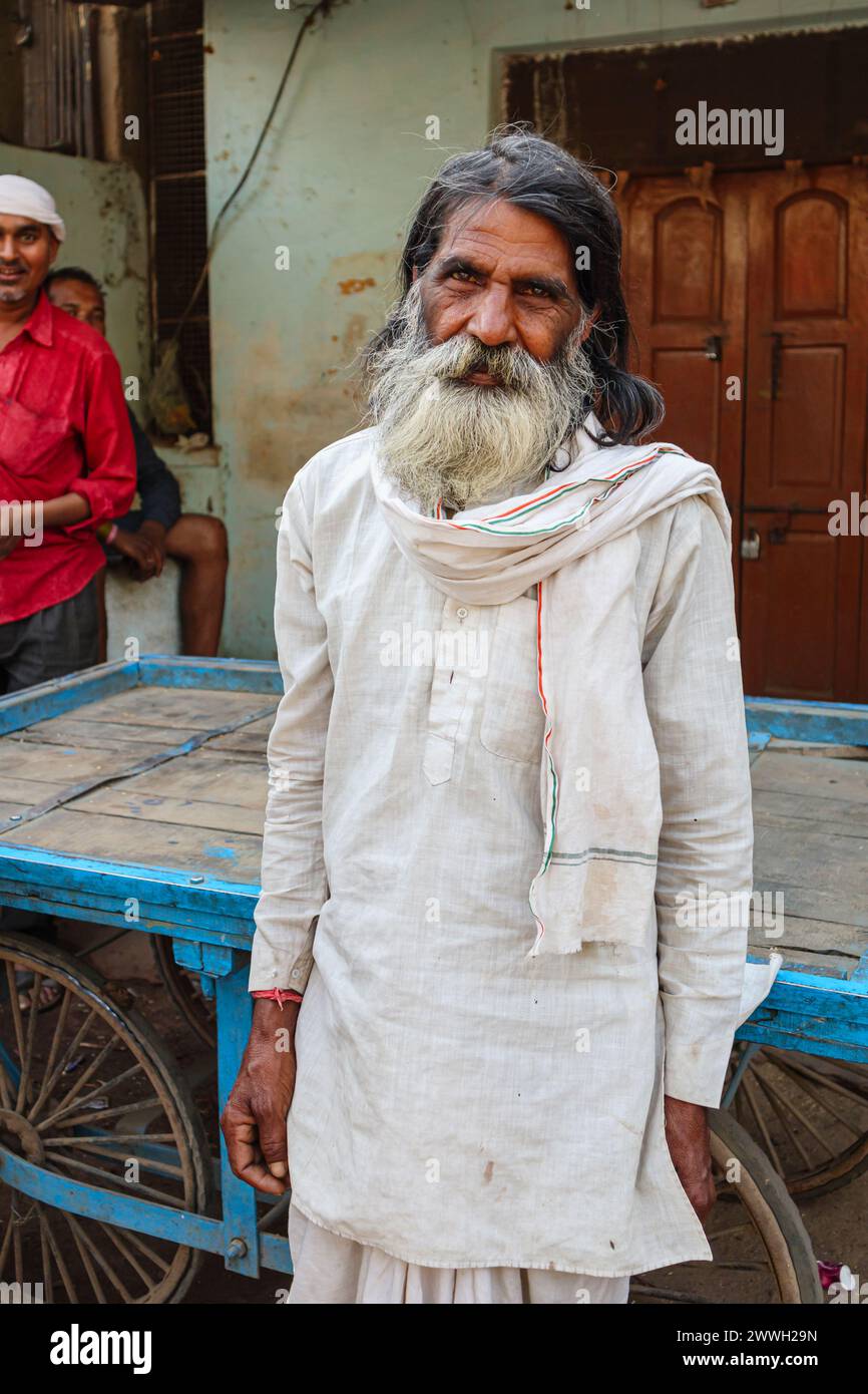 Heavily bearded elderly local Indian man in typical everyday dress standing on the roadside in a town in Umaria district of Madhya Pradesh, India Stock Photo