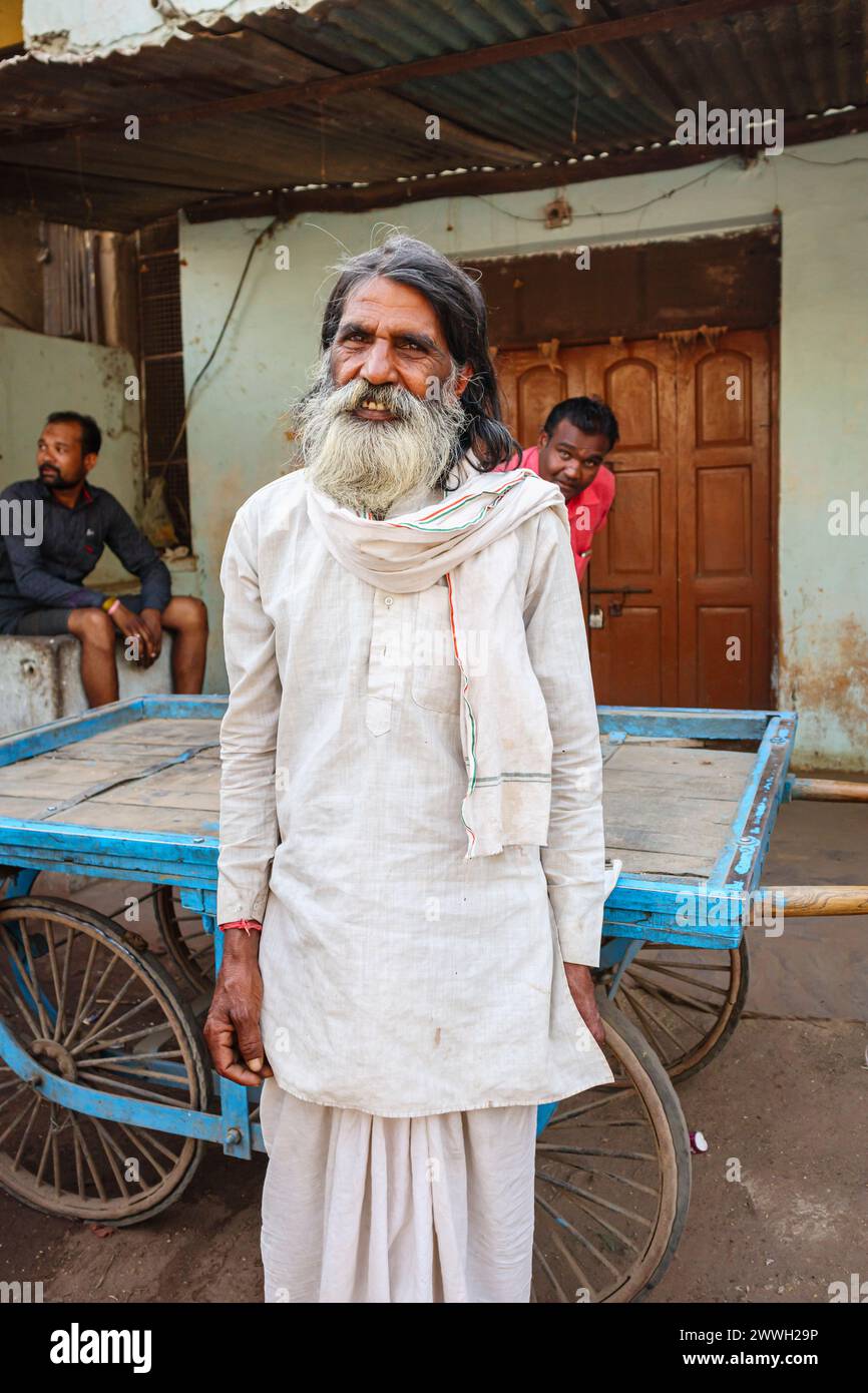 Heavily bearded elderly local Indian man in typical everyday dress standing on the roadside in a town in Umaria district of Madhya Pradesh, India Stock Photo