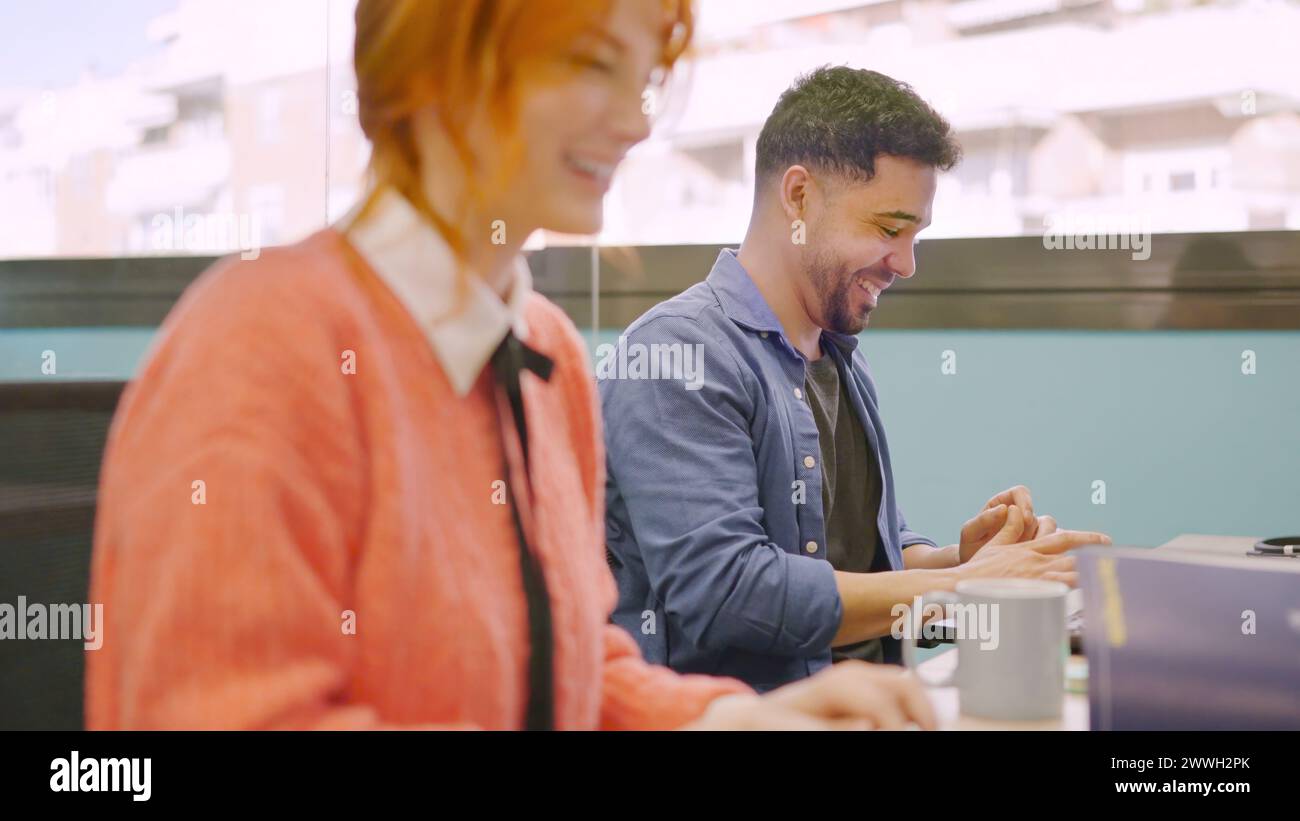 Coworkers smiling while working together with computers Stock Photo