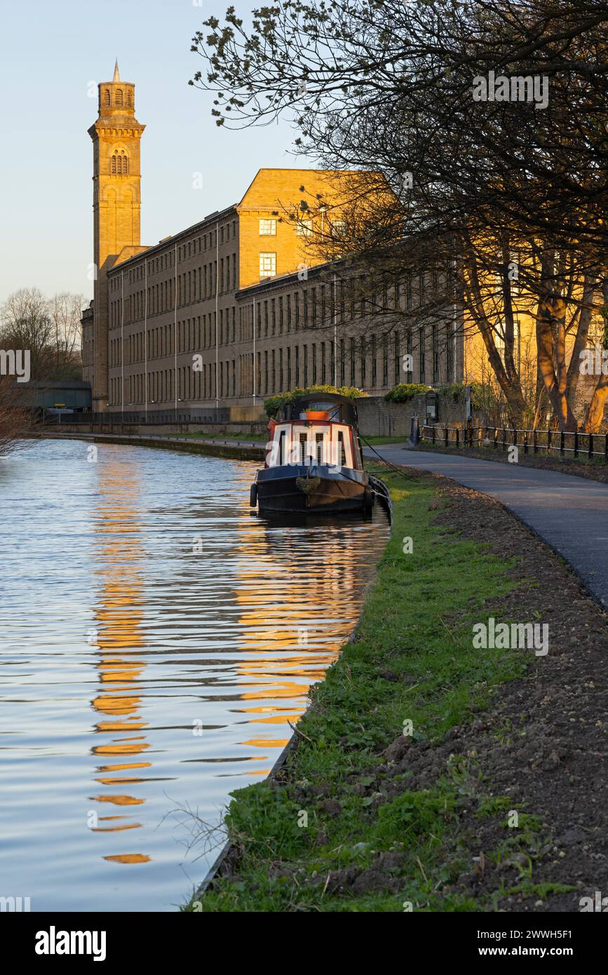 The Italianate tower of New Mill, Saltaire, reflects in the waters of the Leeds-Liverpool Canal, near Bradford, West Yorkshire Stock Photo