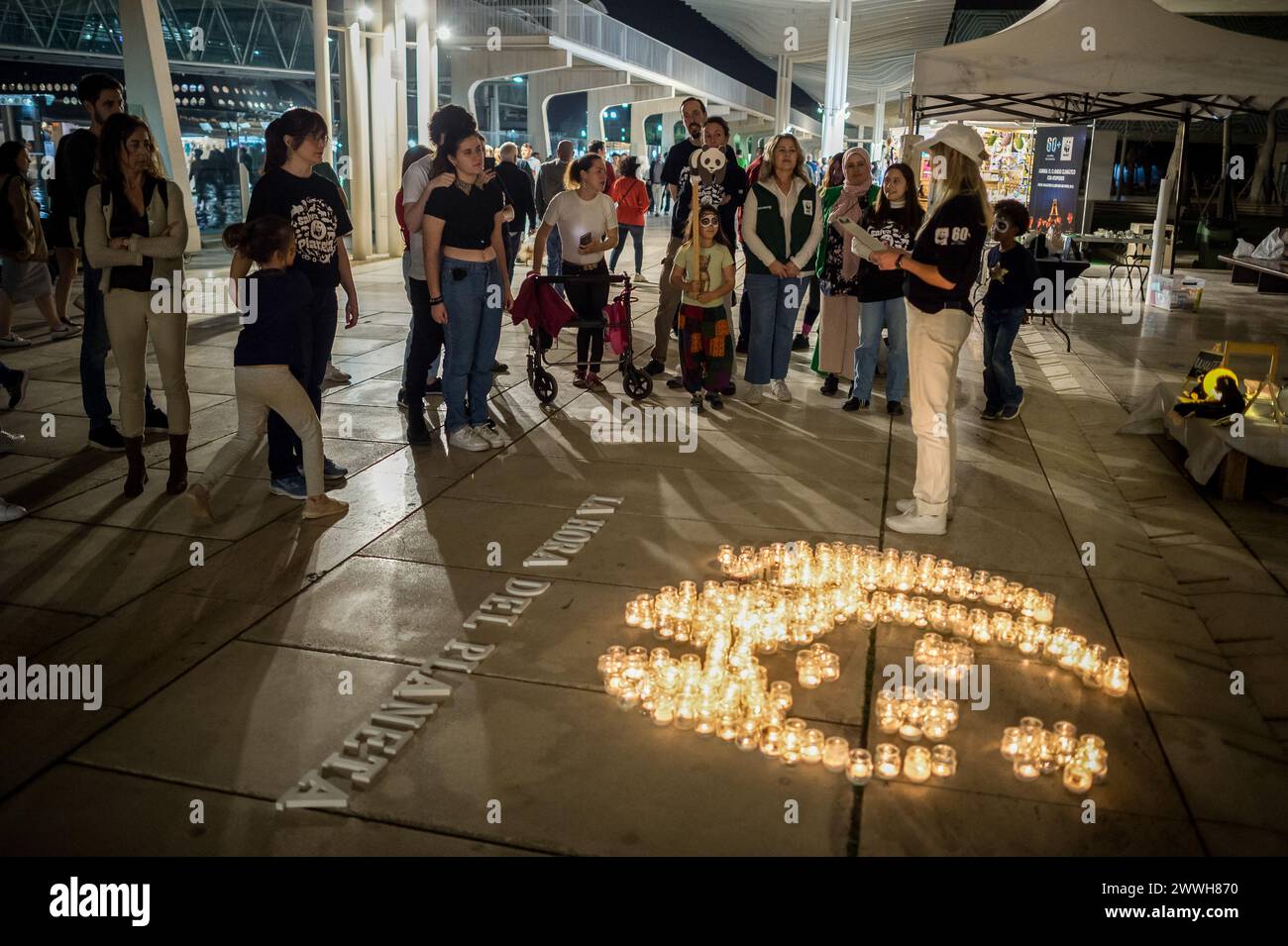Malaga, Spain. 23rd Mar, 2024. Members of the World Wildlife Foundation (WWF) are seen listening to a manifesto during the Earth Hour in the centre of Malaga. The figure made with candles is a panda, the symbol of the WWF. Thousands of cities worldwide switched off their electric lights during Earth Hour to highlight the dangers of climate change. (Photo by Jesus Merida/SOPA Images/Sipa USA) Credit: Sipa USA/Alamy Live News Stock Photo