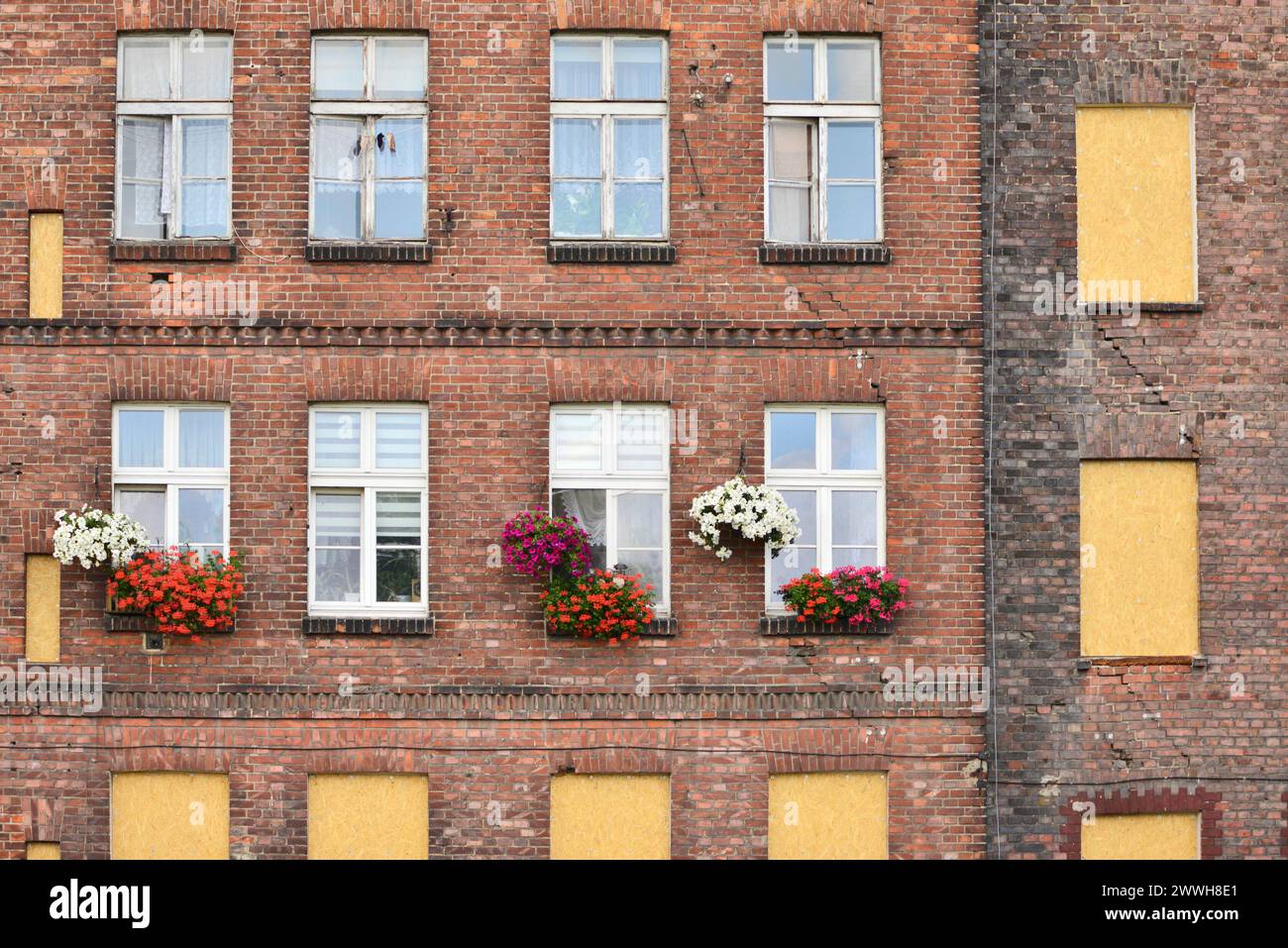 Inhabited apartments in an abandoned old granary building as juxtaposition social issue housing concept in Gdansk, Poland, Europe, EU Stock Photo
