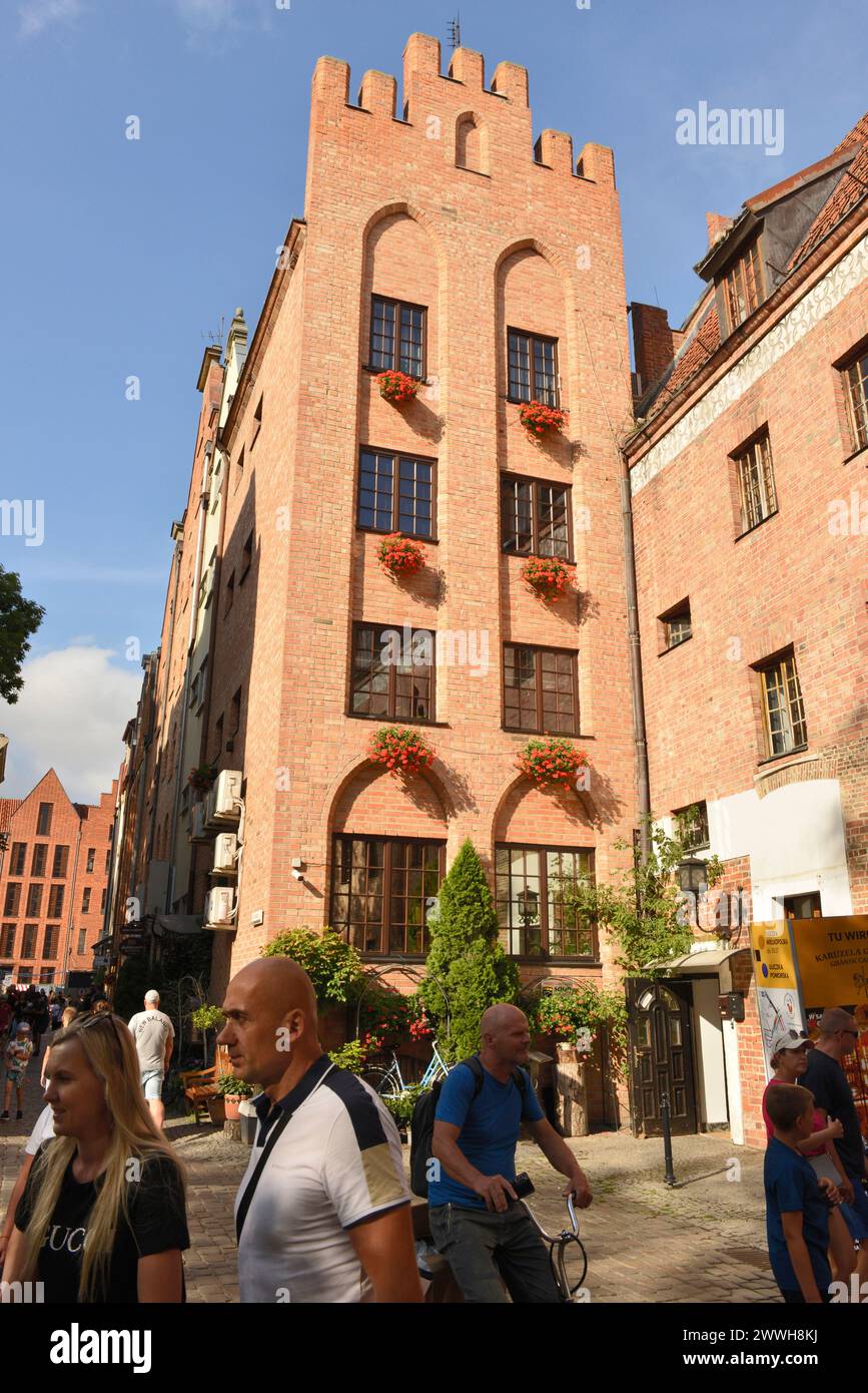 Old Town of Gdansk restored red bricks building facade and flower baskets in Swietago Ducha Street, Gdansk, Poland, Europe, EU Stock Photo