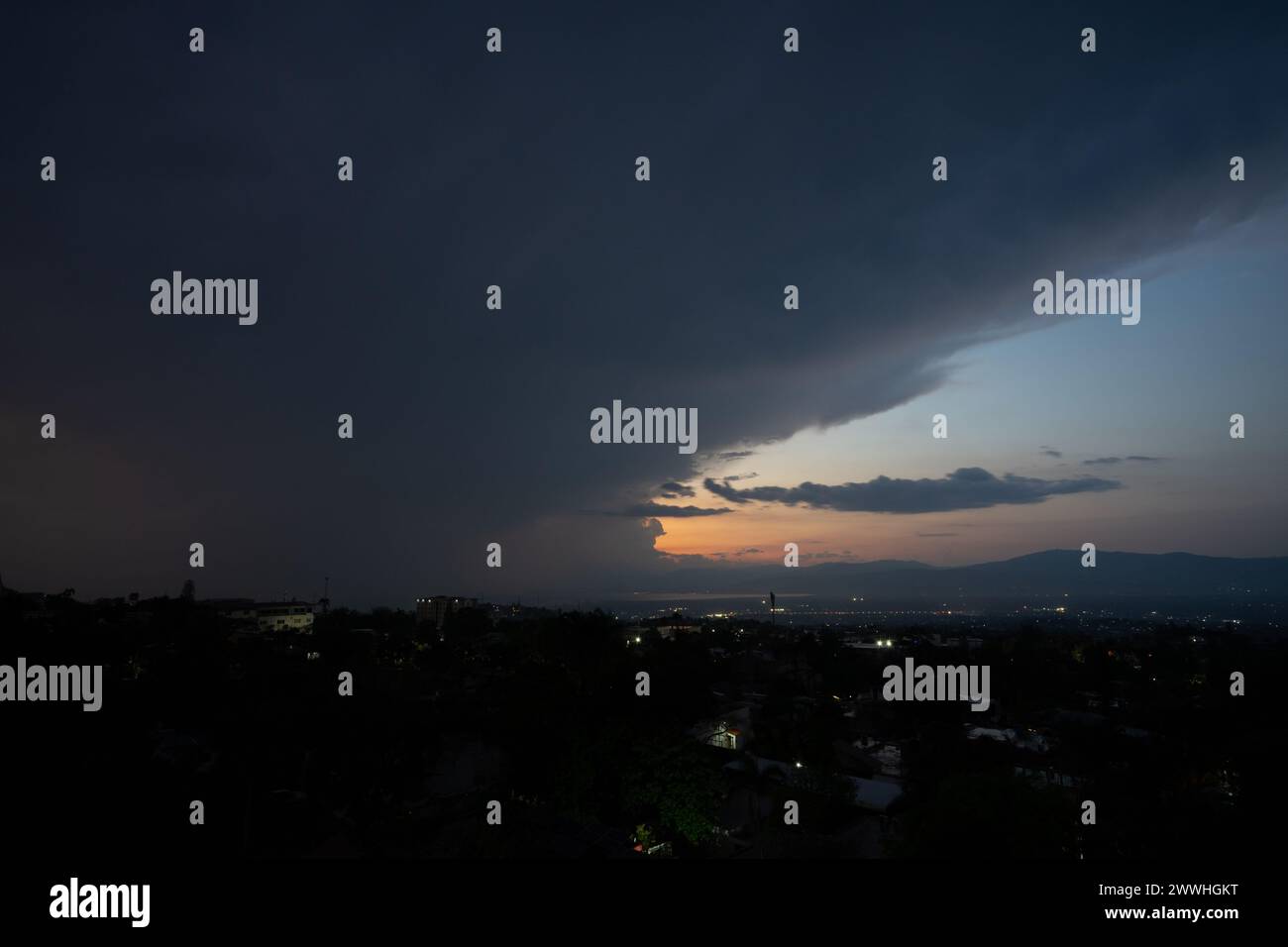 Lightning bolt falling over the city of Port-au-Prince, Haiti with dramatic clouds on one side and a colorful sunset on the other Stock Photo