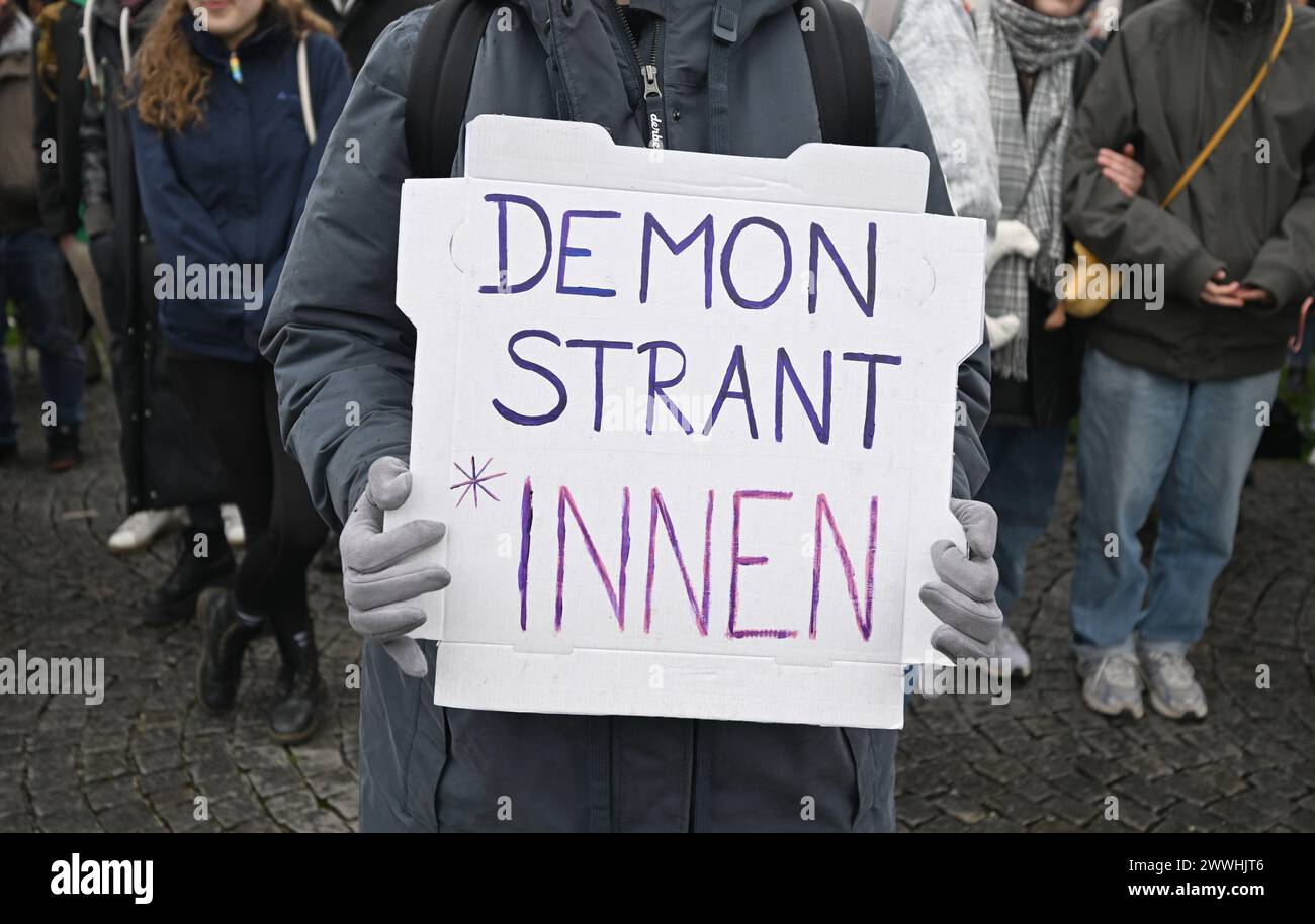 Munich, Germany. 24th Mar, 2024. A demonstrator holds a poster with the inscription 'Demonstrant*innen' during a demonstration against the gender ban on Gärtnerplatz. Credit: Felix Hörahger/dpa/Alamy Live News Stock Photo