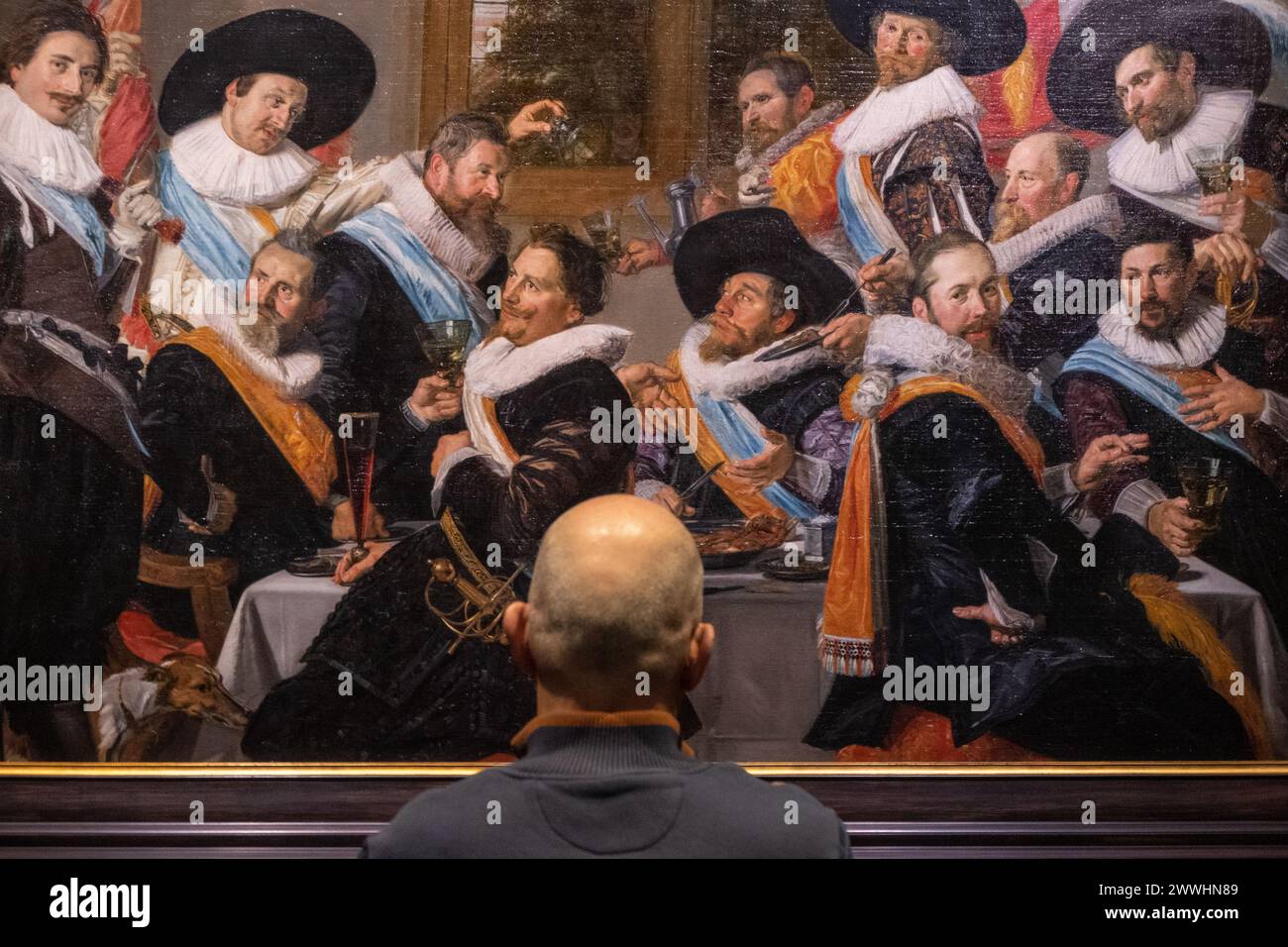 visitor looking at 'Banquet of the Callivrmen Civic Guard' by dutch painter Frans Hals Stock Photo