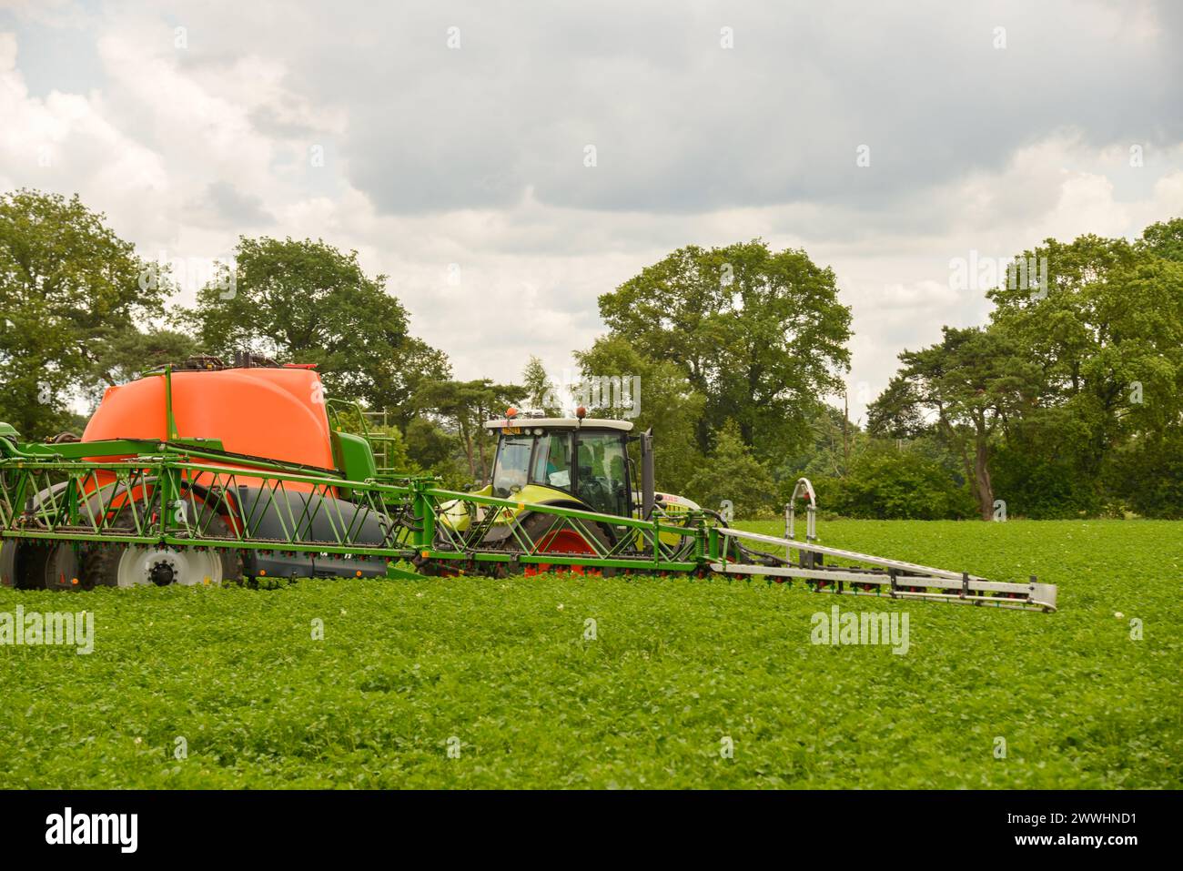 tractor spraying herbicide at farmland Stock Photo