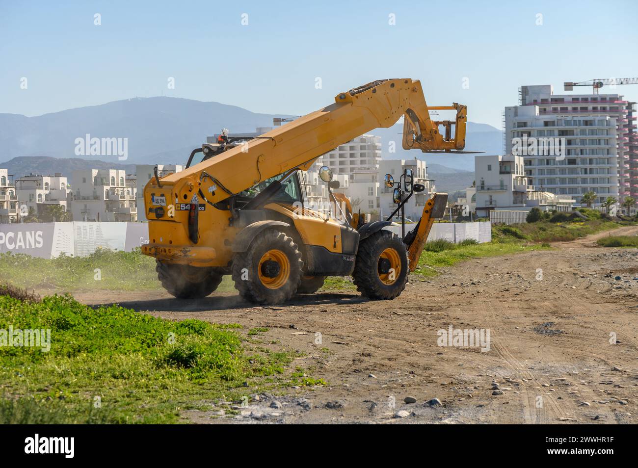 Gaziveren Cyprus 04/03/2024 - front loader driving along a dirt road 1 Stock Photo