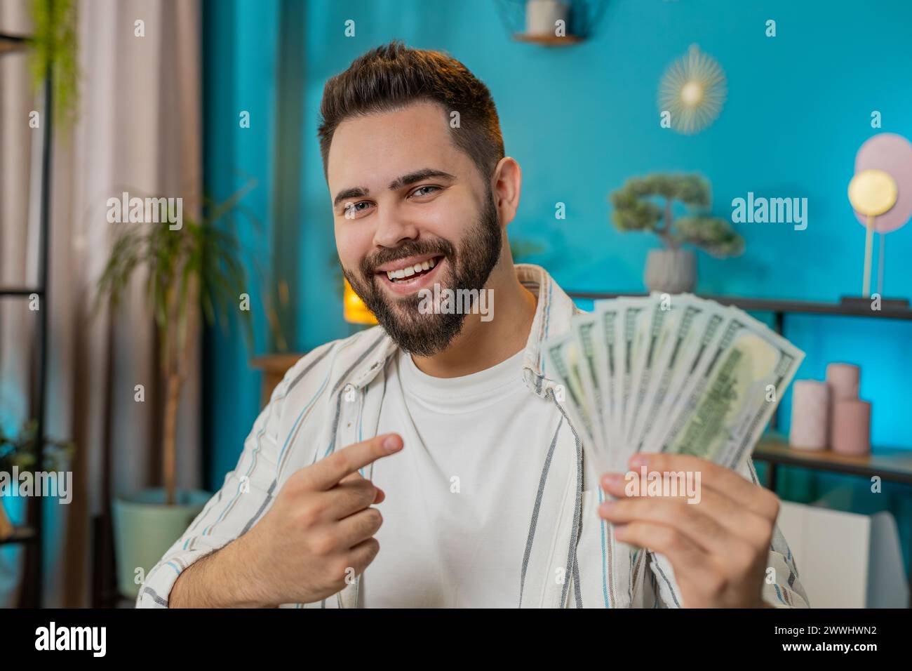 Young happy businessman guy holding fan of cash money dollar banknotes ...