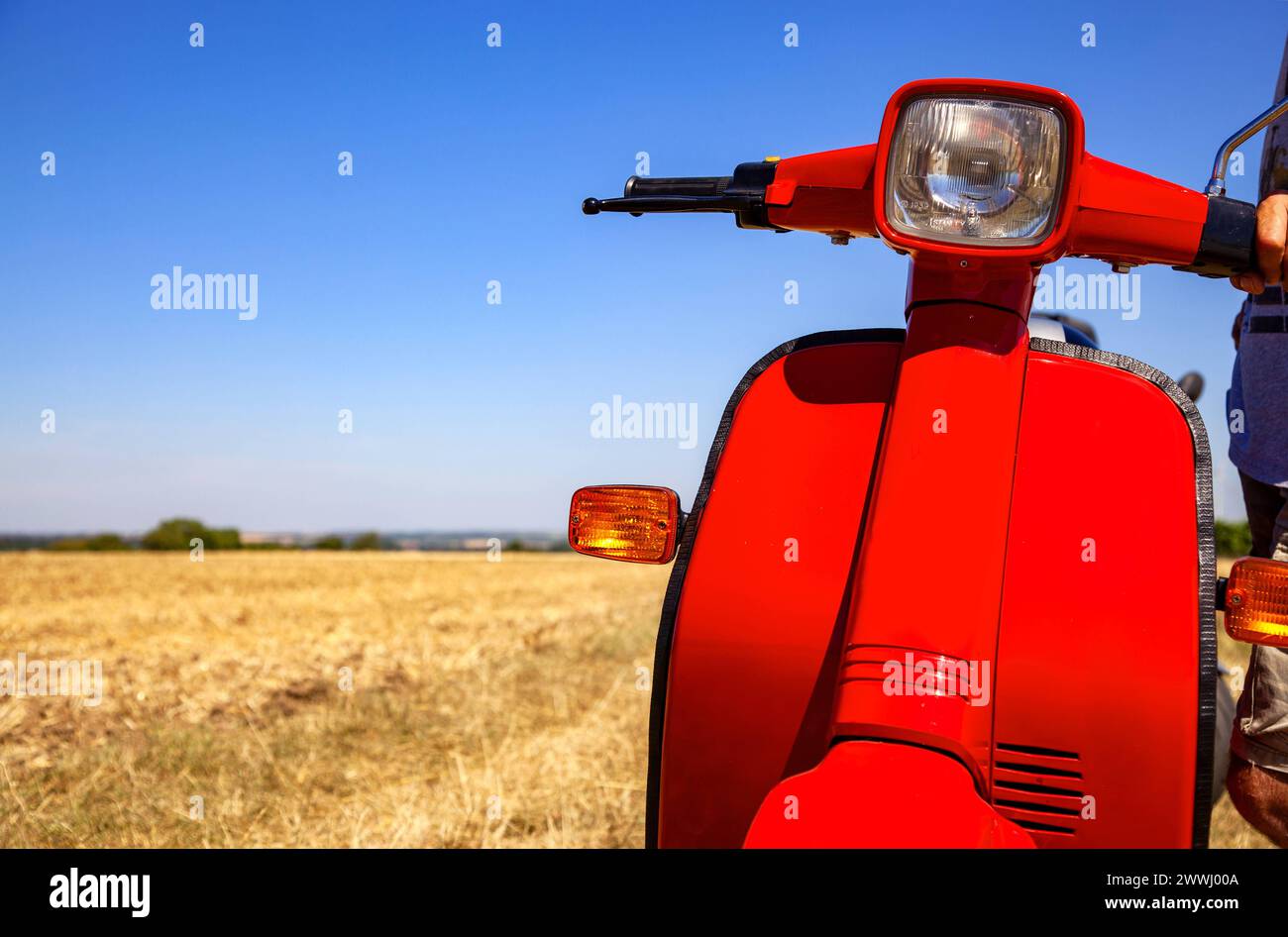 classic scooter on spacious field of drying grass in the heat of the summer with copy space classic scooter on spacious classic scooter on spacious fi Stock Photo