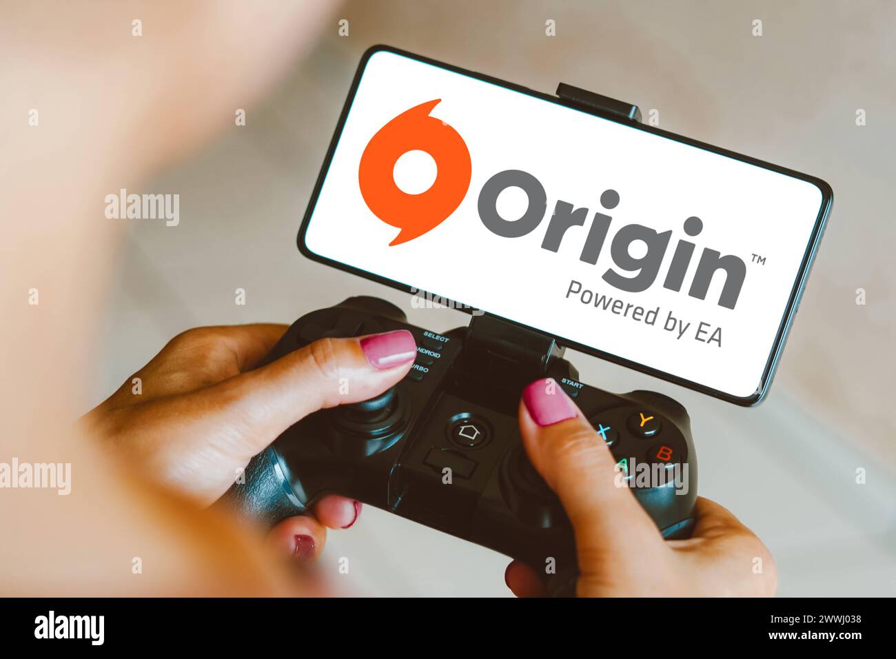 December 4, 2023, Brazil. In this photo illustration, the Origin logo is displayed on a smartphone screen as a person pl December 4, 2023, Brazil. In Stock Photo