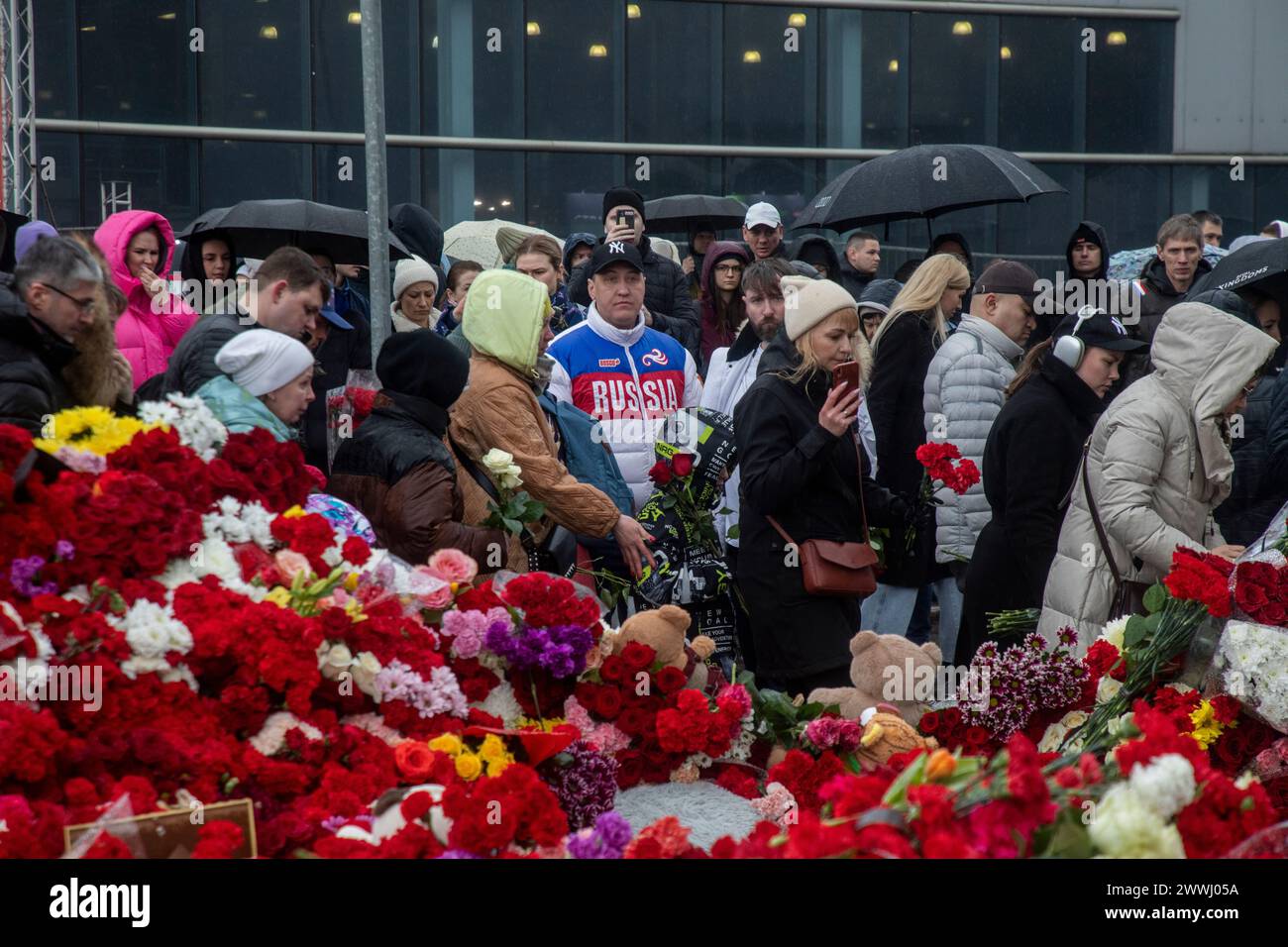 Moscow region, Russia. 24th of March, 2024. People bring flowers to a makeshift memorial outside the Crocus City Hall to commemorating the terrorist attack victims, Russia. Unidentified gunmen opened fire before the start of a concert at the Crocus City Hall in the town of Krasnogorsk near Moscow, and set off explosives that started a massive fire in the building. According to recent reports, 133 people were killed and 285 injured. Credit: Nikolay Vinokurov/Alamy Live News Stock Photo