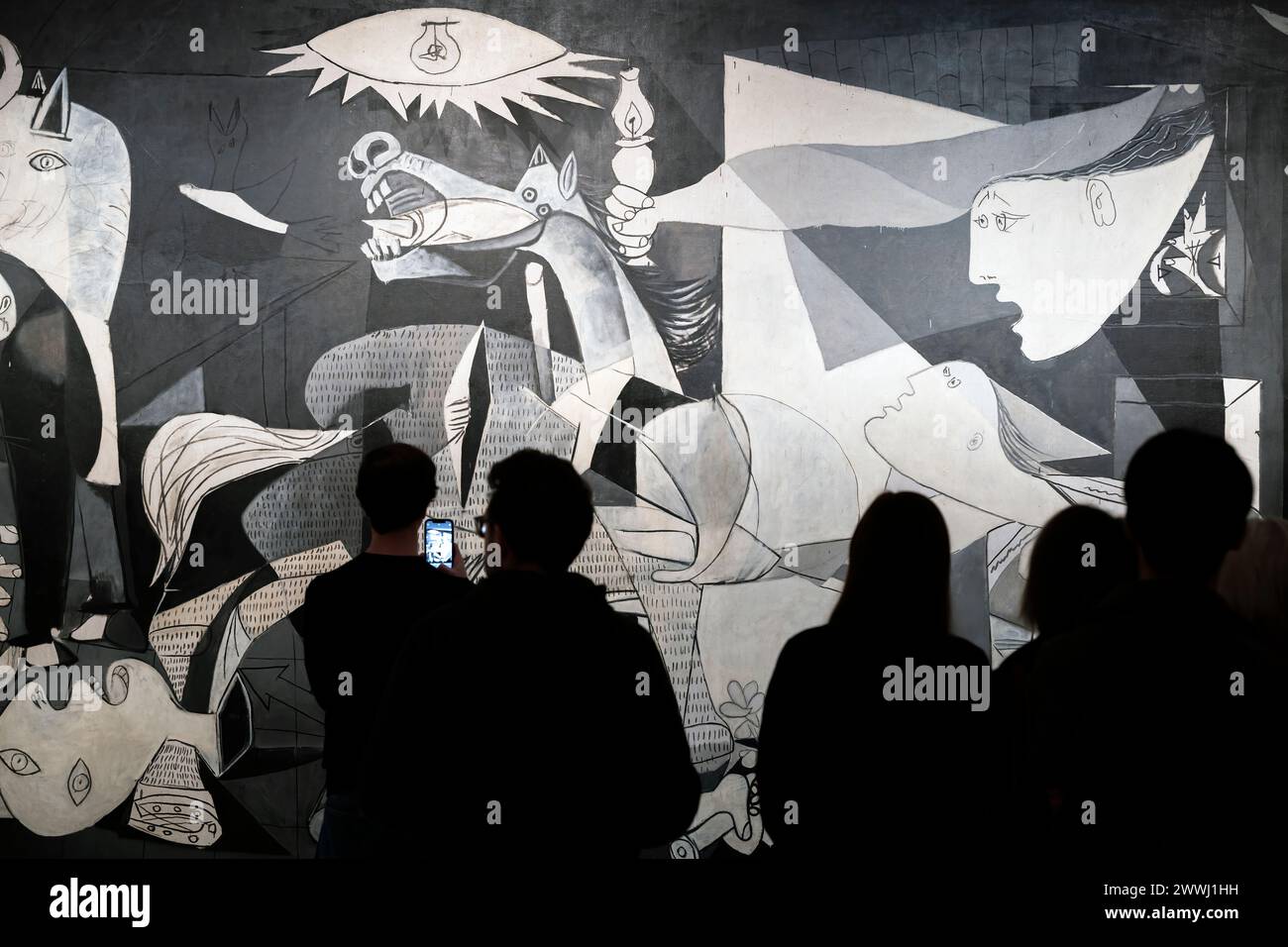 Visitors watching the 'Guernica' oil painting by Spanish artist Pablo Picasso, Reina Sofia museum, Madrid, Spain Stock Photo