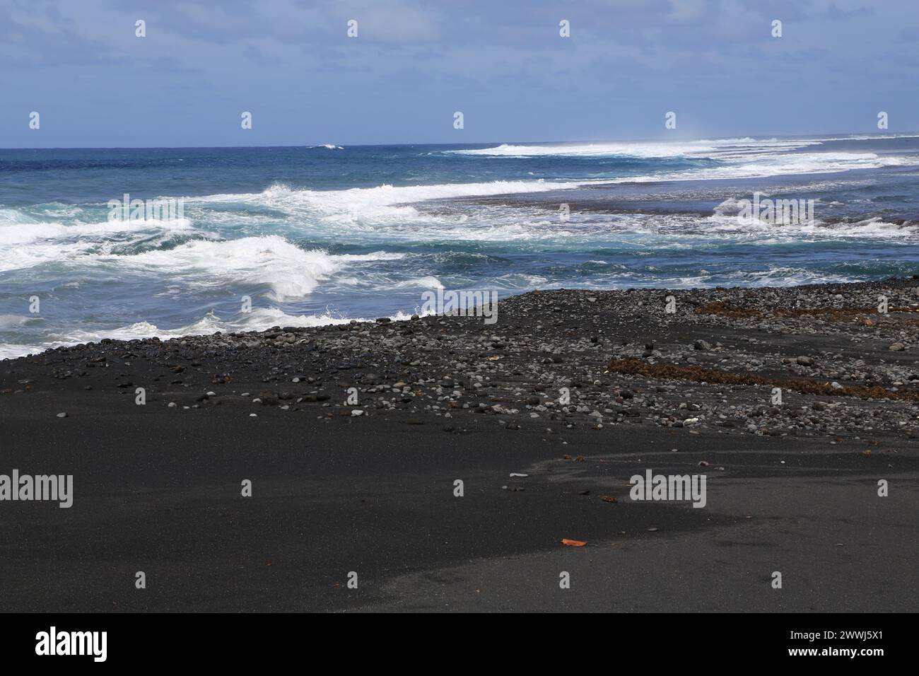 Black sand beach at Papara on the volcanic island of Tahiti in French Polynesia. This coastline with the Pacific Ocean is an ideal surf spot for all l Stock Photo
