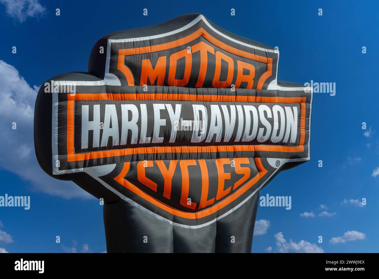 Italy - March 24, 2024: Harley Davidson logo on large inflatable sign on blue sky, clipping path included, Harley-Davidson Motor Company is historic U Stock Photo