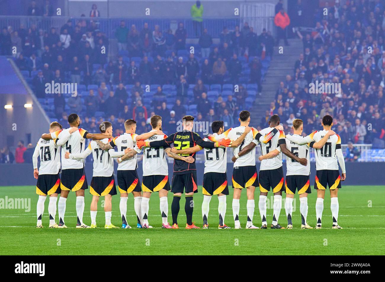 Team France and Germany in a memorial minute for the deceased former DFB player Andi Brehme and Franz Beckenbauer with Maximilian Mittelstädt, DFB 18 Jonathan Tah, DFB 4 Florian Wirtz, Nr. 17 DFB Toni Kroos, DFB 8 Robert Andrich, DFB 23 Marc-Andre ter STEGEN, DFB 22 Ilkay Gündogan, DFB 21 Kai Havertz, DFB 7 Antonio Rüdiger, Ruediger, DFB 2 Joshua Kimmich, DFB 6 Jamal Musiala, DFB 10   in the friendly match FRANCE - GERMANY  0-2  FRANKREICH - DEUTSCHLAND 0-2 in preparation for European Championships 2024  on Mar 23, 2024  in Lyon, France.  © Peter Schatz / Alamy Live News Stock Photo