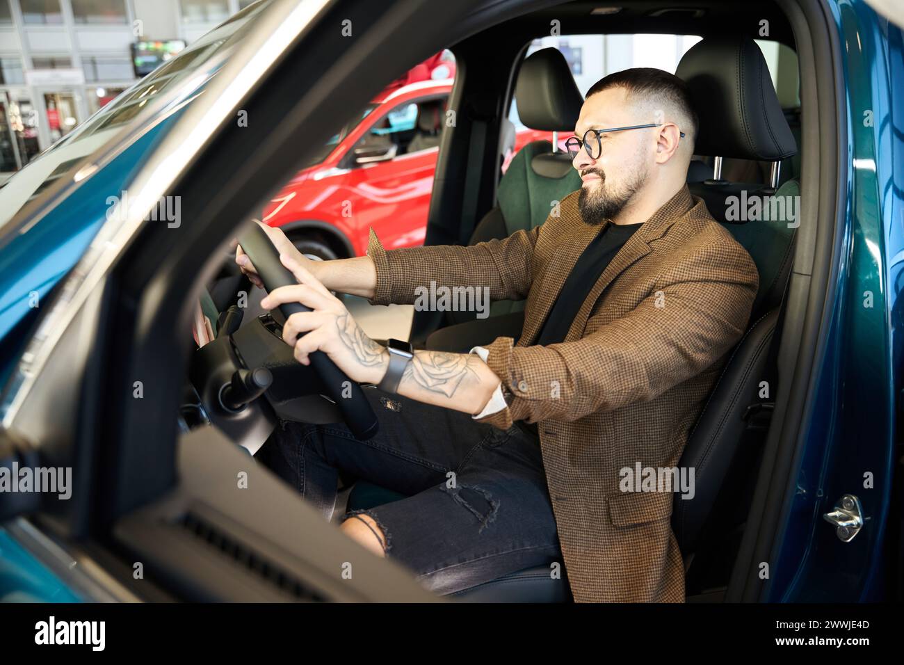 Guy smiles while sitting behind the wheel of a car Stock Photo - Alamy