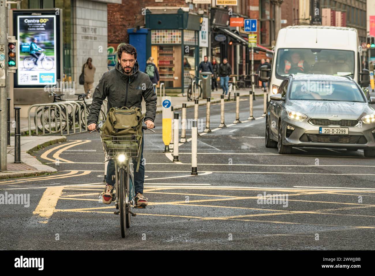 Man cyclist in the busy city centre on city bike blending seamlessly