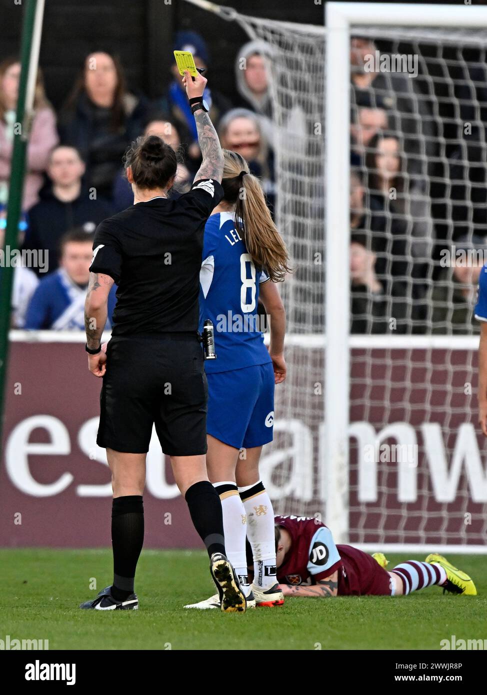 Dagenham, UK. 24th Mar, 2024. Womens Super League. West Ham V Chelsea. Chigwell Construction Stadium. Dagenham. Megan Wilson (Referee) shows the yellow card to Melanie Leupolz (Chelsea, 8) during the West Ham V Chelsea Womens Super League match at the Chigwell Construction Stadium, Dagenham. Credit: Sport In Pictures/Alamy Live News Stock Photo