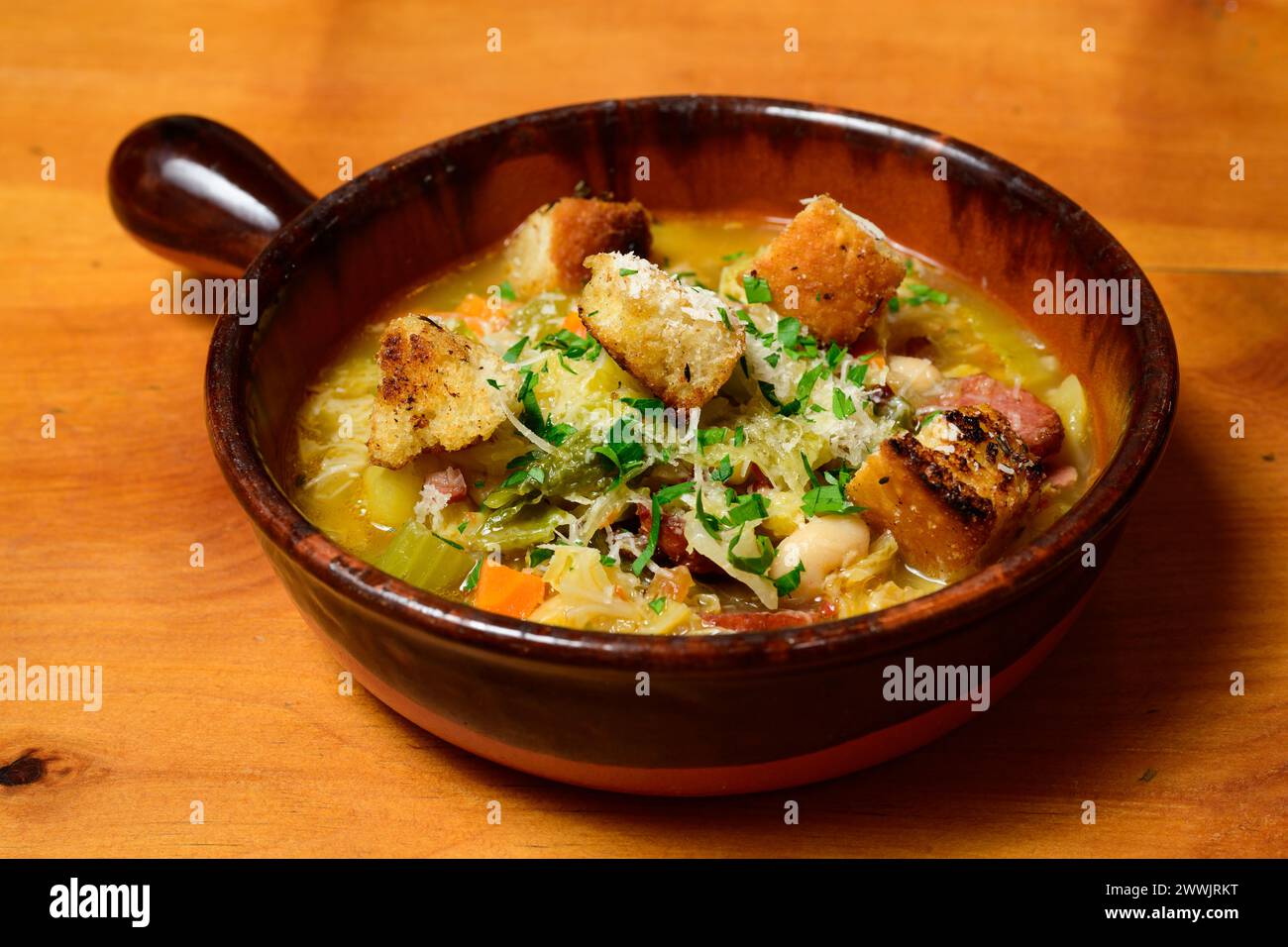 Ribollita Italian Bread and Bean Soup from Tuscany with Winter Vegetables in a Terracotta Bowl Stock Photo