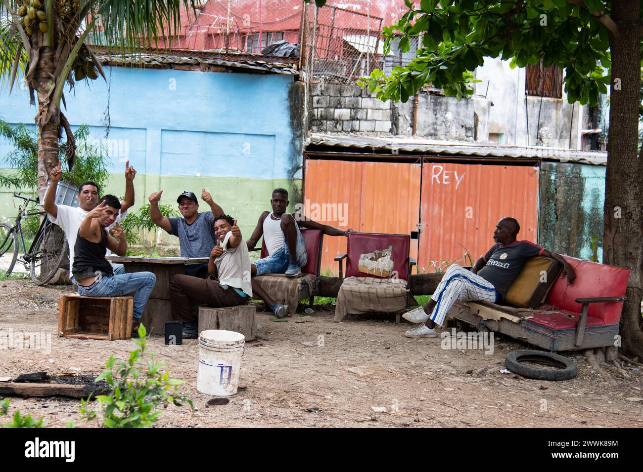Young men with thumbs up playing dominoes on a warm day in a park in Havana, Cuba. Stock Photo