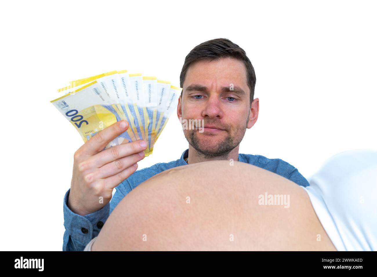 Description: Father-to-be with banknotes in hand contemplates pregnant baby bump thoughtfully. Last month of pregnancy - week 39. White background. Br Stock Photo