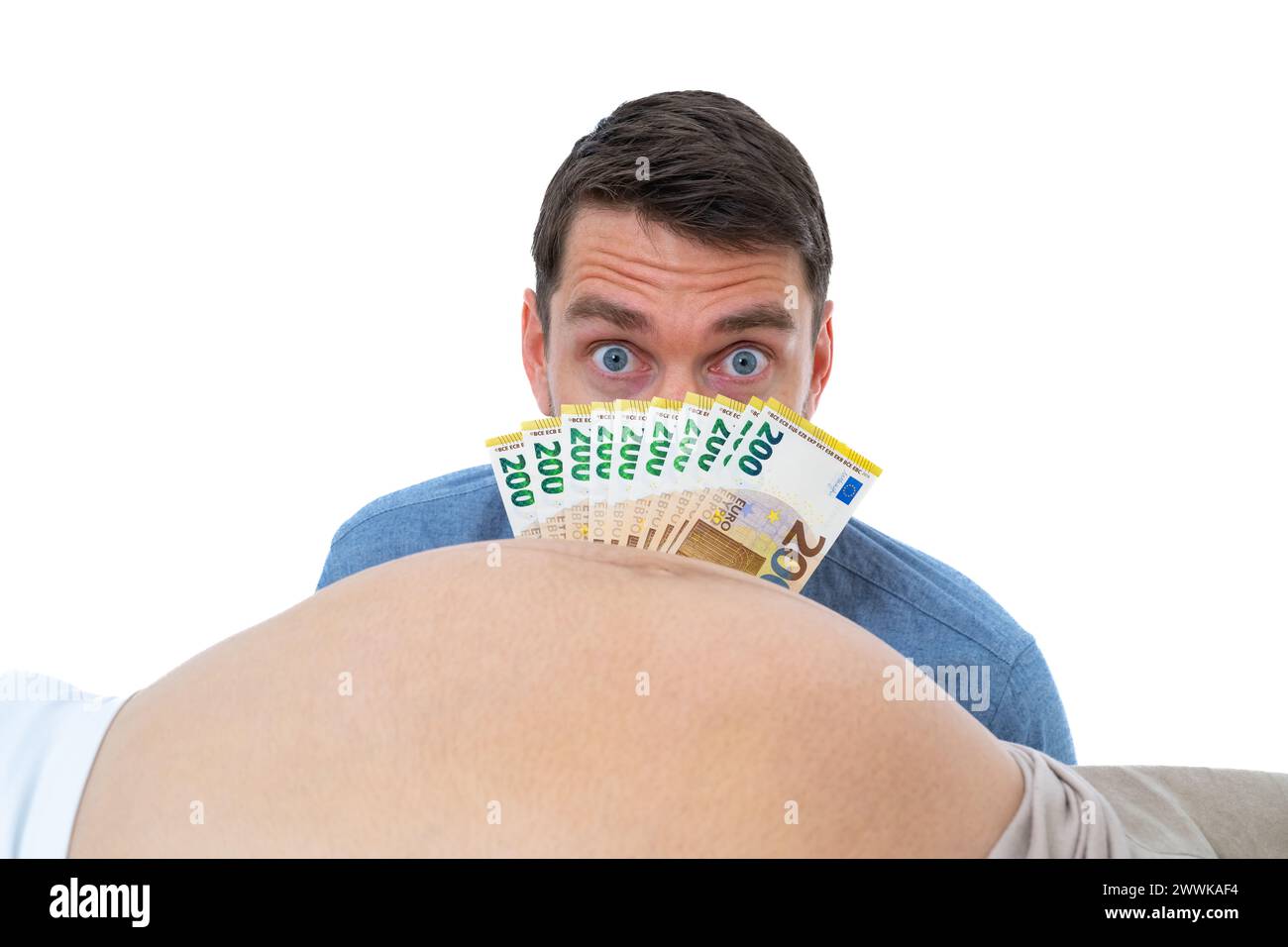 Description: Expectant father in front of pregnant baby bump holds banknotes in front of his face and looks worried. Last month of pregnancy - week 39 Stock Photo