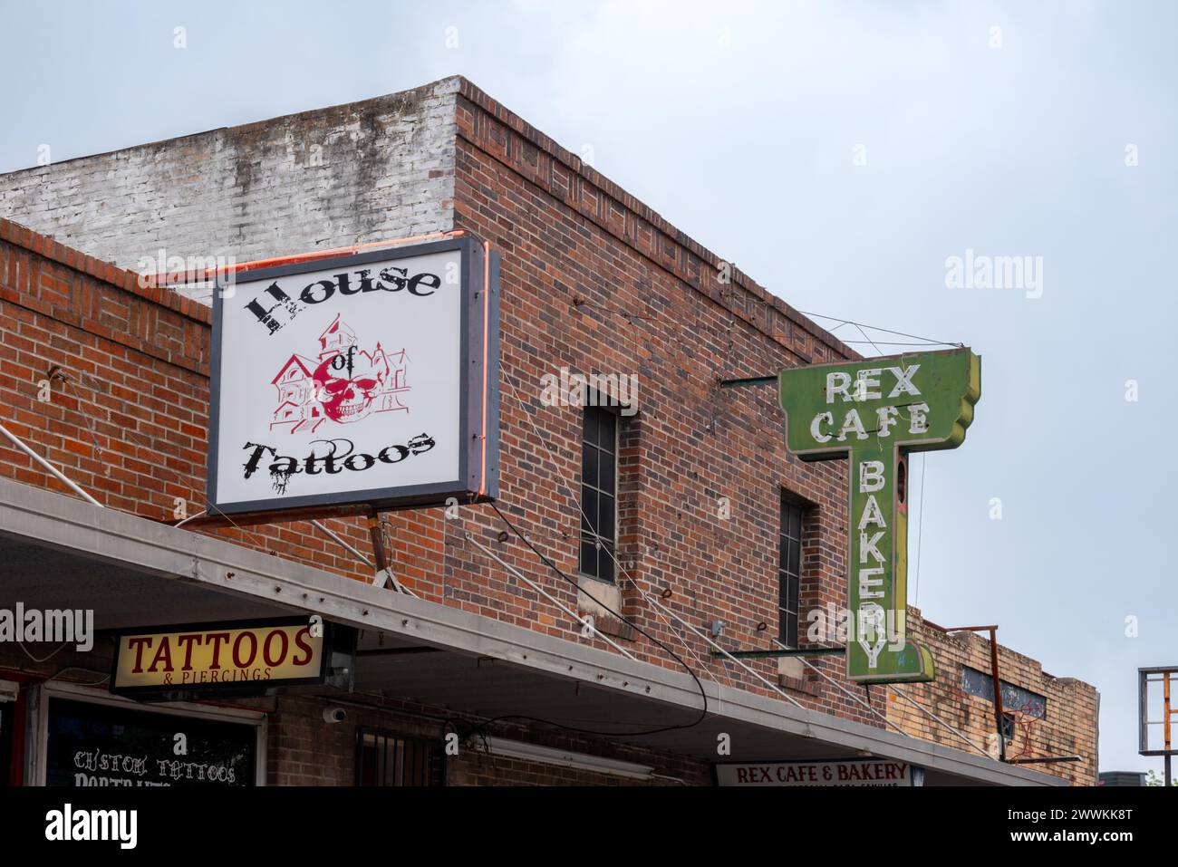 Facade of brick and signs for Rex Cafe, opened 1947, a restaurant in downtown McAllen, and House of Tattoos, Hidalgo County, Texas, USA. Stock Photo