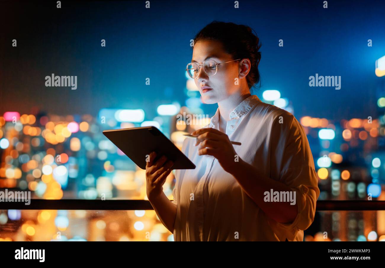 Young businesswoman standing near window with tablet pc. Stock Photo