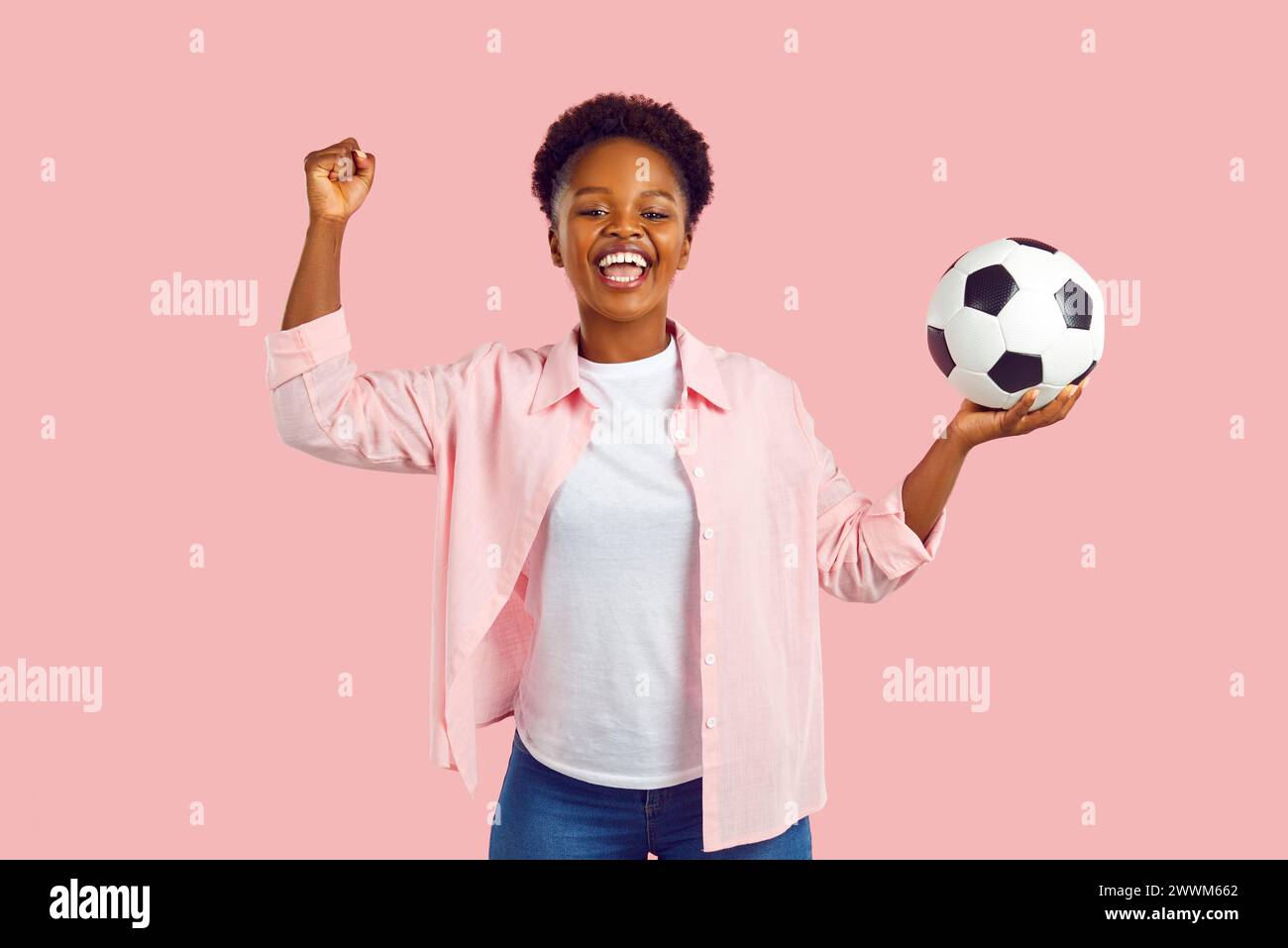 Soccer fan woman saying yes showing win gesture holding football ball ...