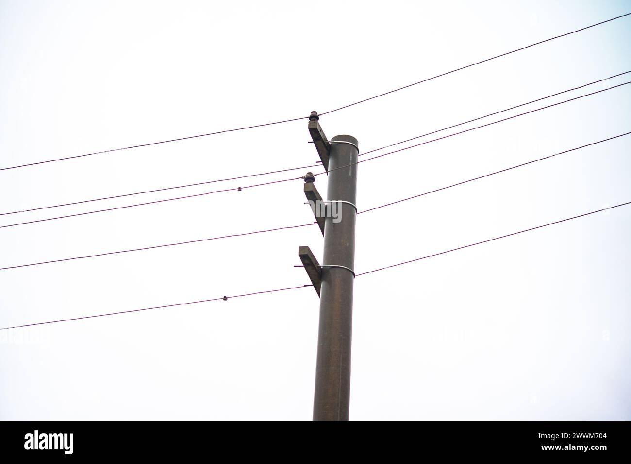 Amidst the cityscape, electric columns and cables weave a web of energy, connecting urban spaces with the invisible pulse of power and modern life Stock Photo