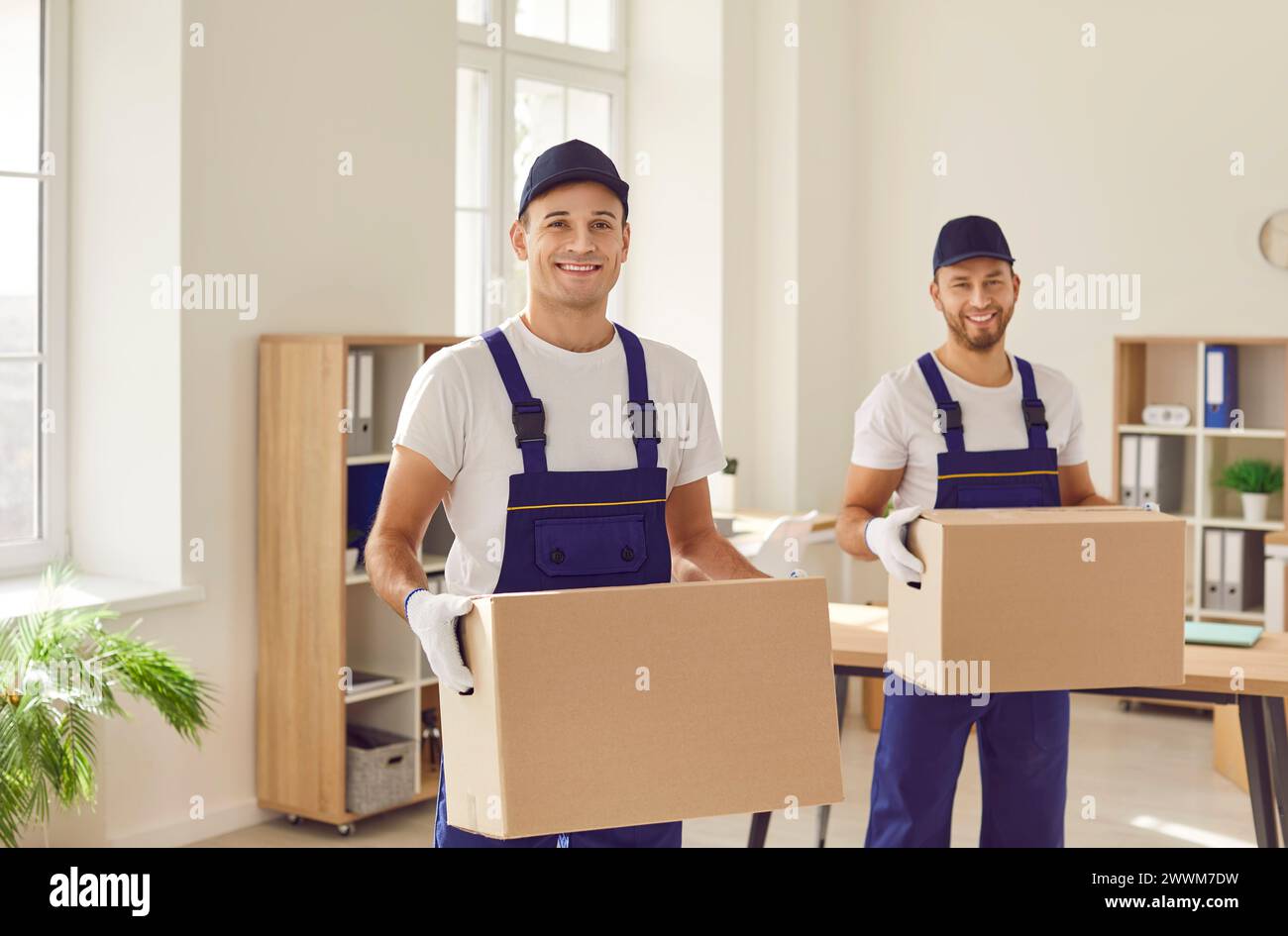 Smiling Movers with Cardboard Boxes during Relocation Stock Photo